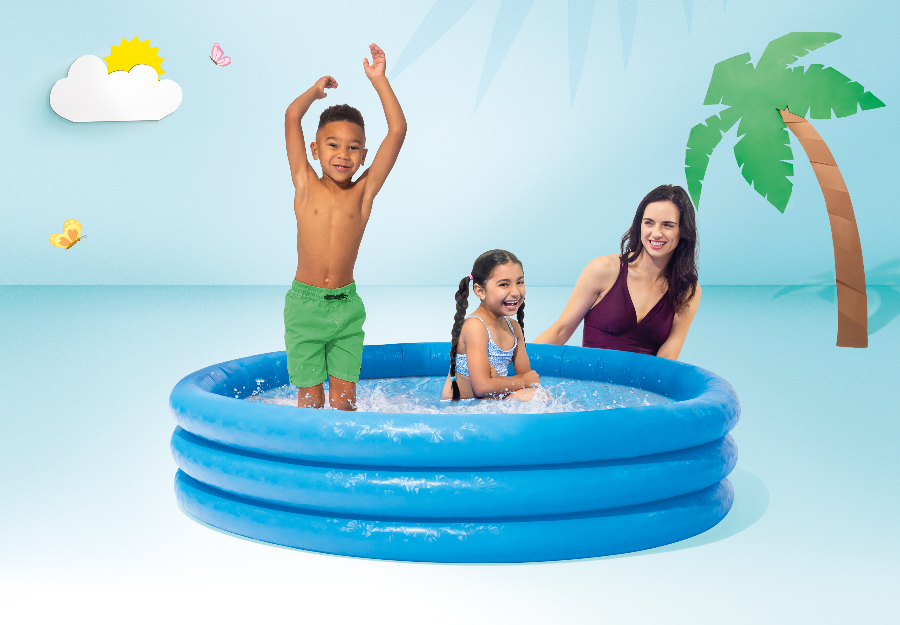 Bambini giocano in una piscina blu con una donna sullo sfondo.
