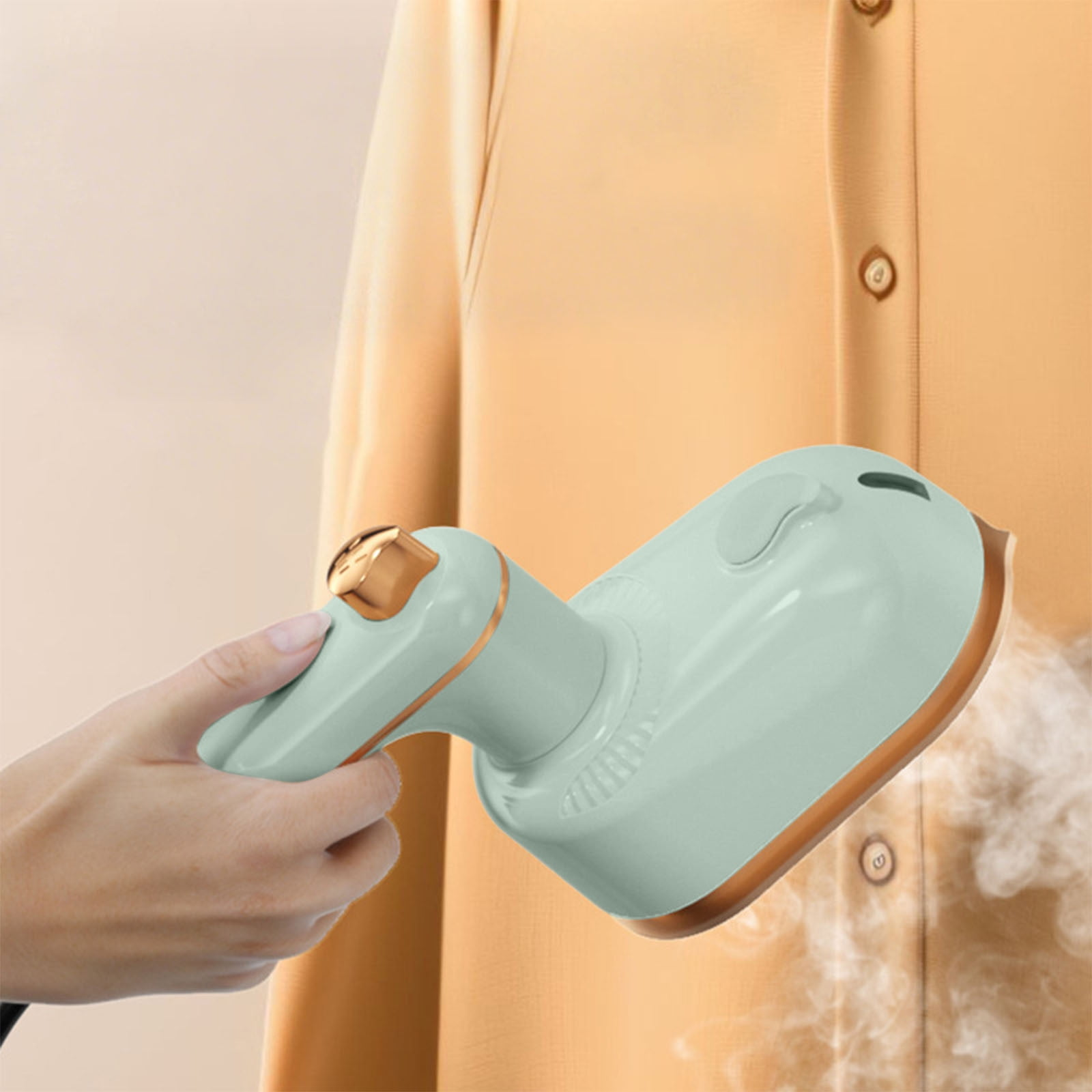 Helles Minz-Handdampfer mit goldenen Akzenten bügelt ein orangefarbenes Hemd.