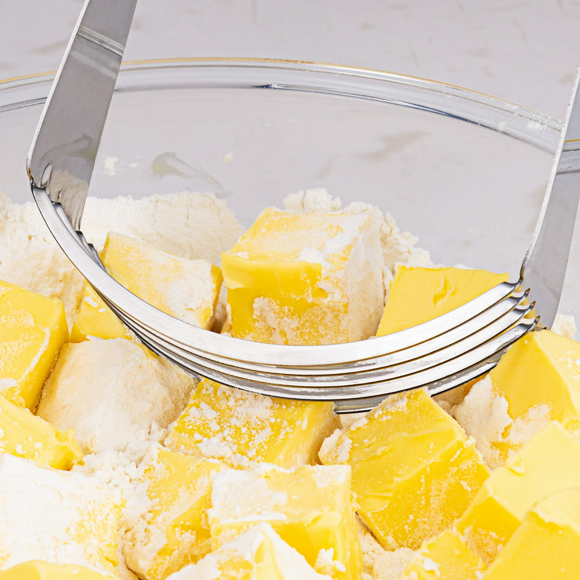 Würfel aus Butter und Mehl in einer Schüssel mit einem Gebäckschneider.