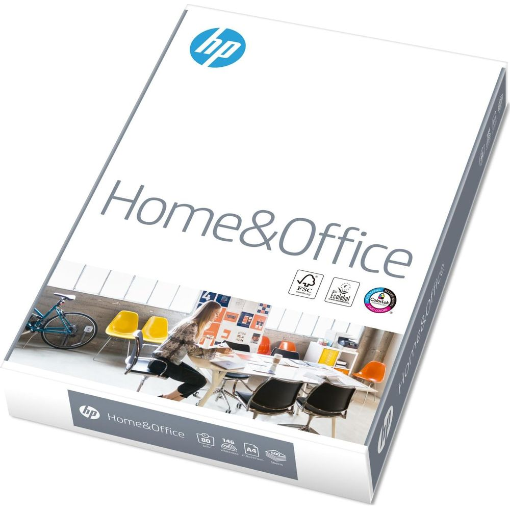 HP Home & Office Papierpaket mit einer Frau, die an einem Tisch in einem modernen Büro sitzt.