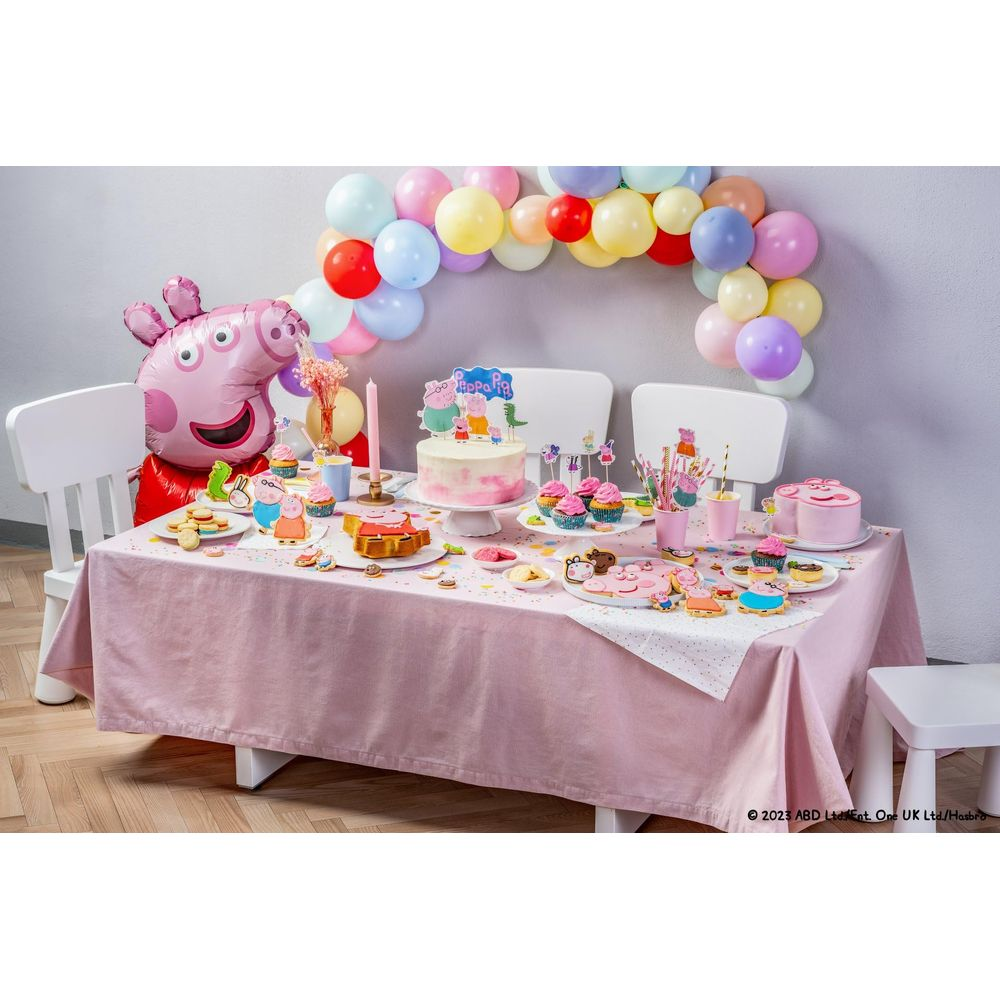 Peppa Wutz Mottoparty Tisch mit Kuchen, Cupcakes, Keksen und Ballonbogen.