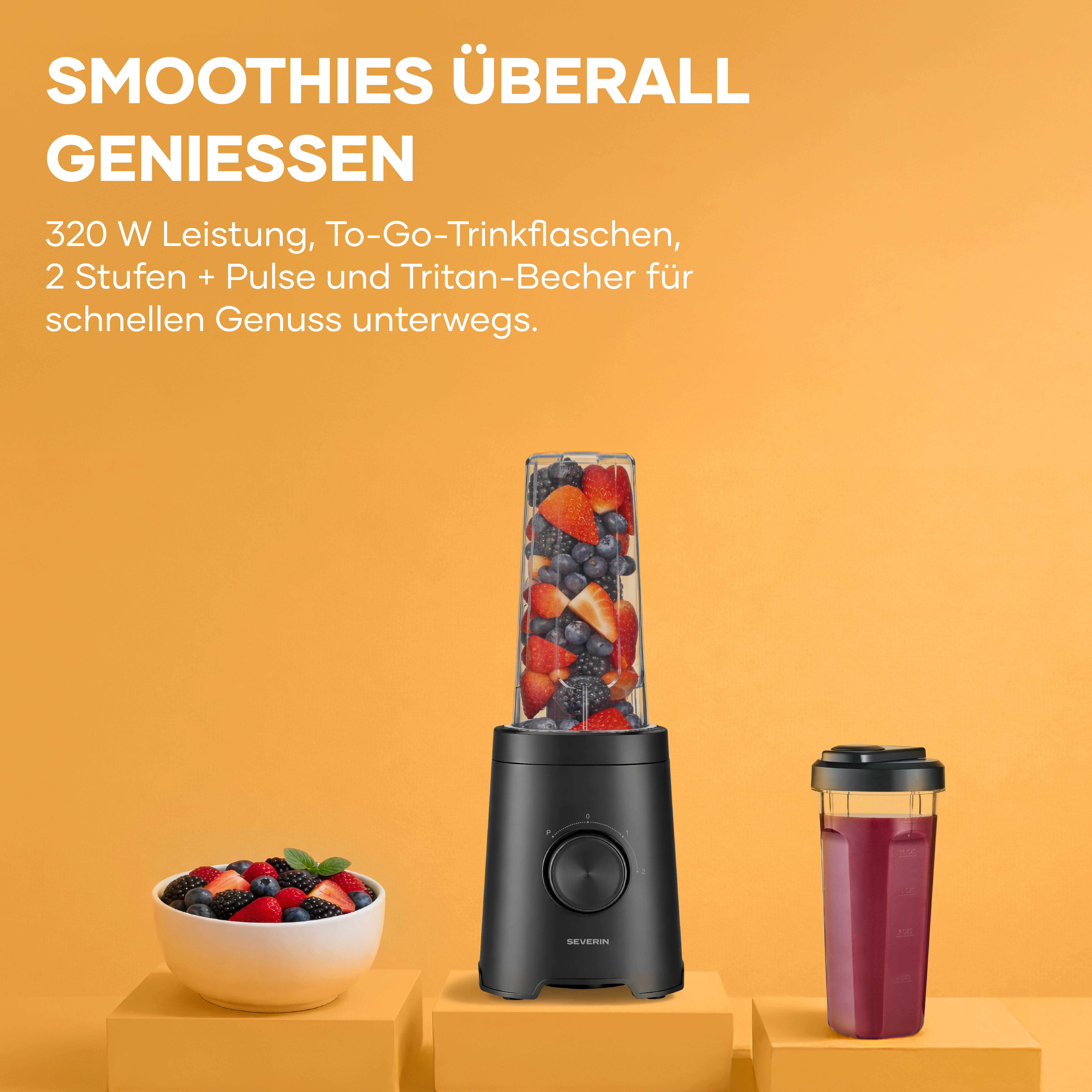 Un frullatore nero con frutta in un bicchiere, ciotola e una tazza da viaggio.