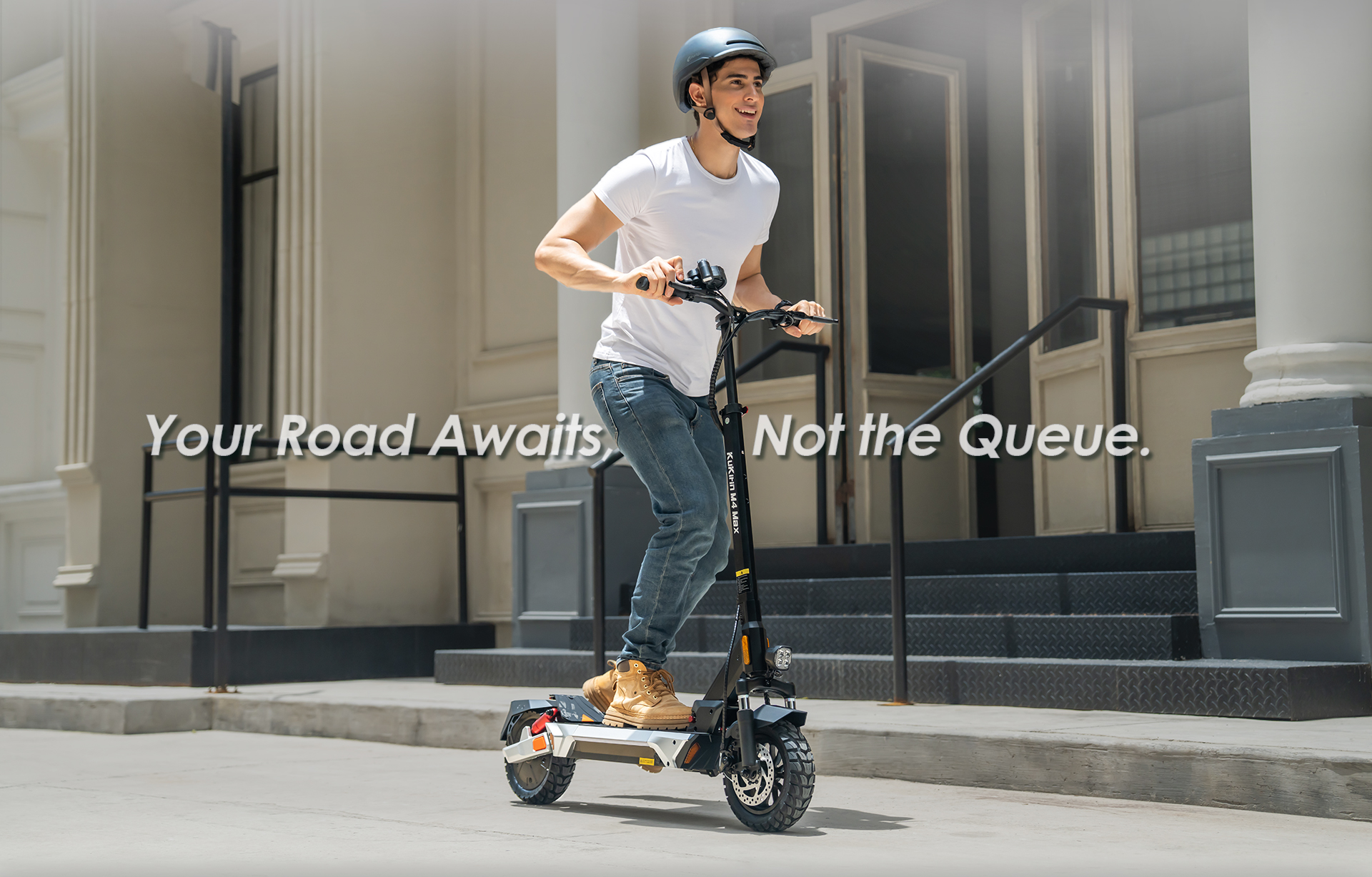 Ein Mann fährt einen E-Scooter auf einer Straße vor einem Gebäude.