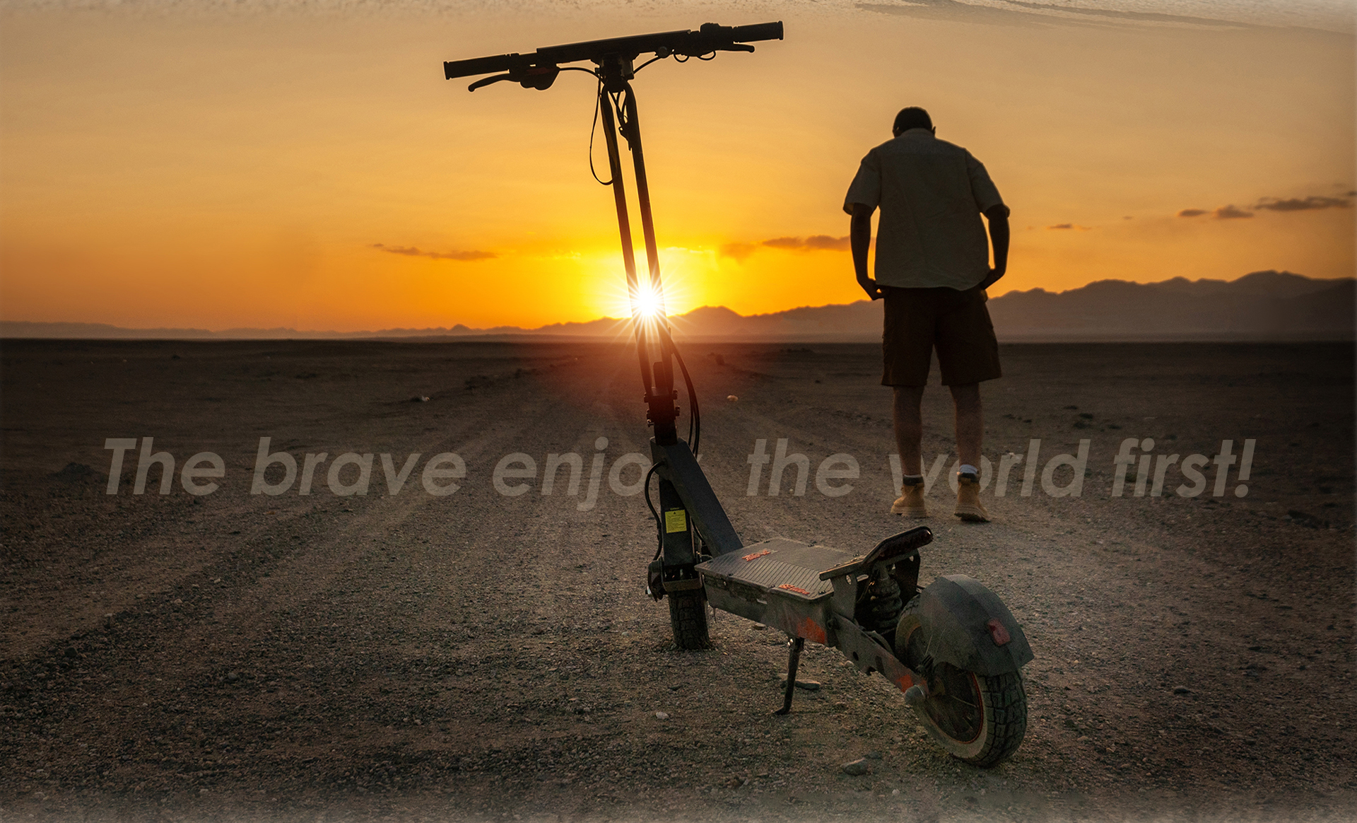 Un uomo e uno scooter su una strada polverosa al tramonto.