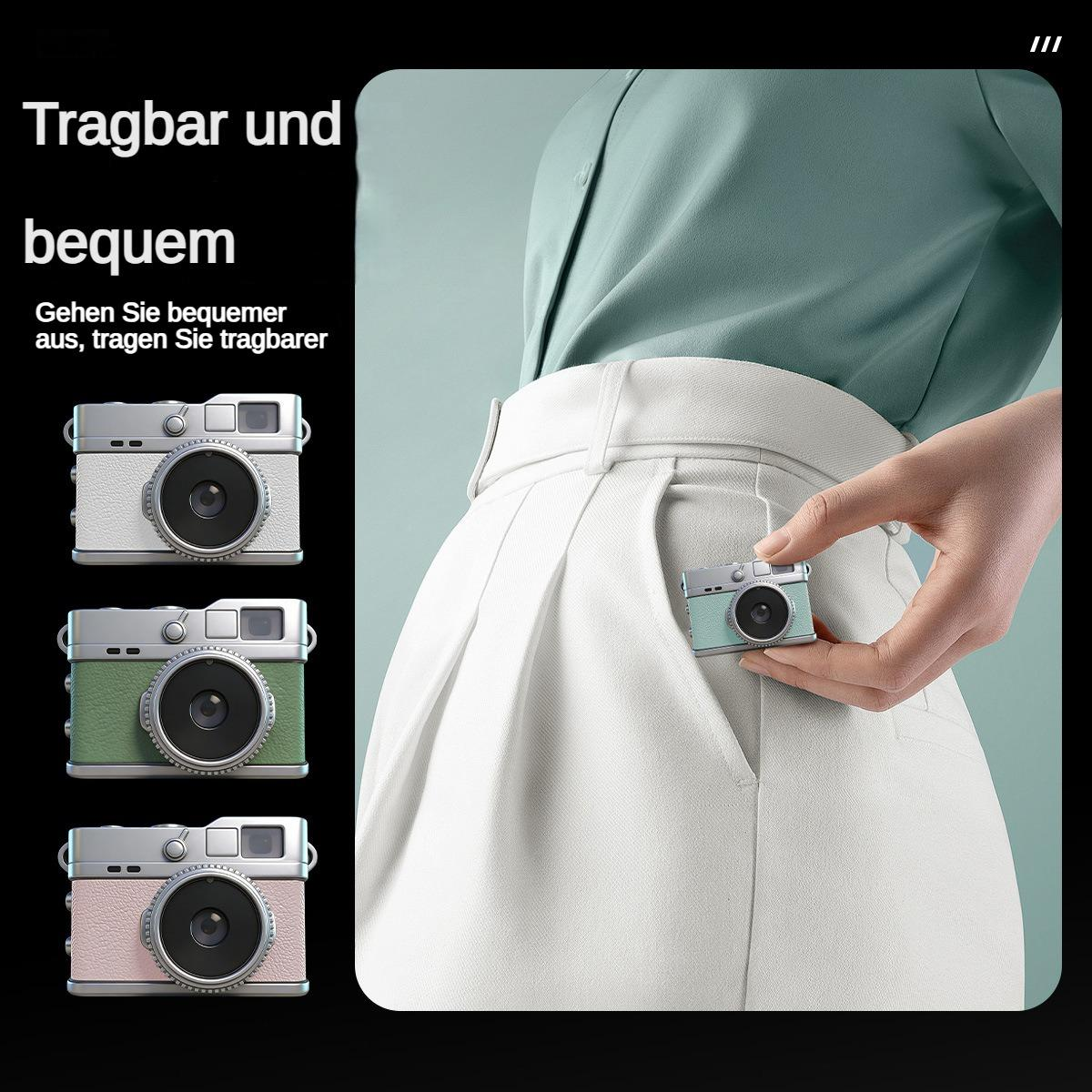 Eine Hand hält eine mintgrüne Minikamera, die in eine weiße Tasche gesteckt wird.
