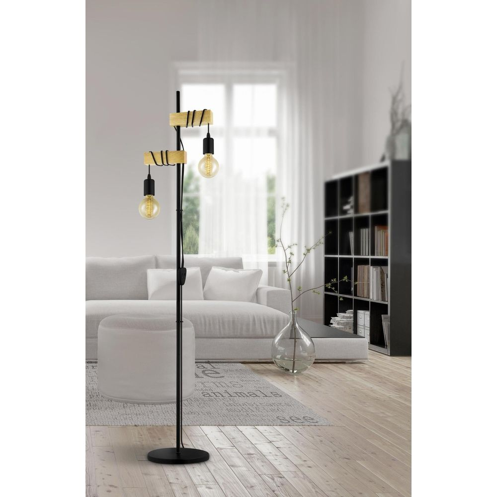 Ein Stehlampe mit zwei Glühbirnen und Holzakzenten in einem modernen Wohnzimmer.