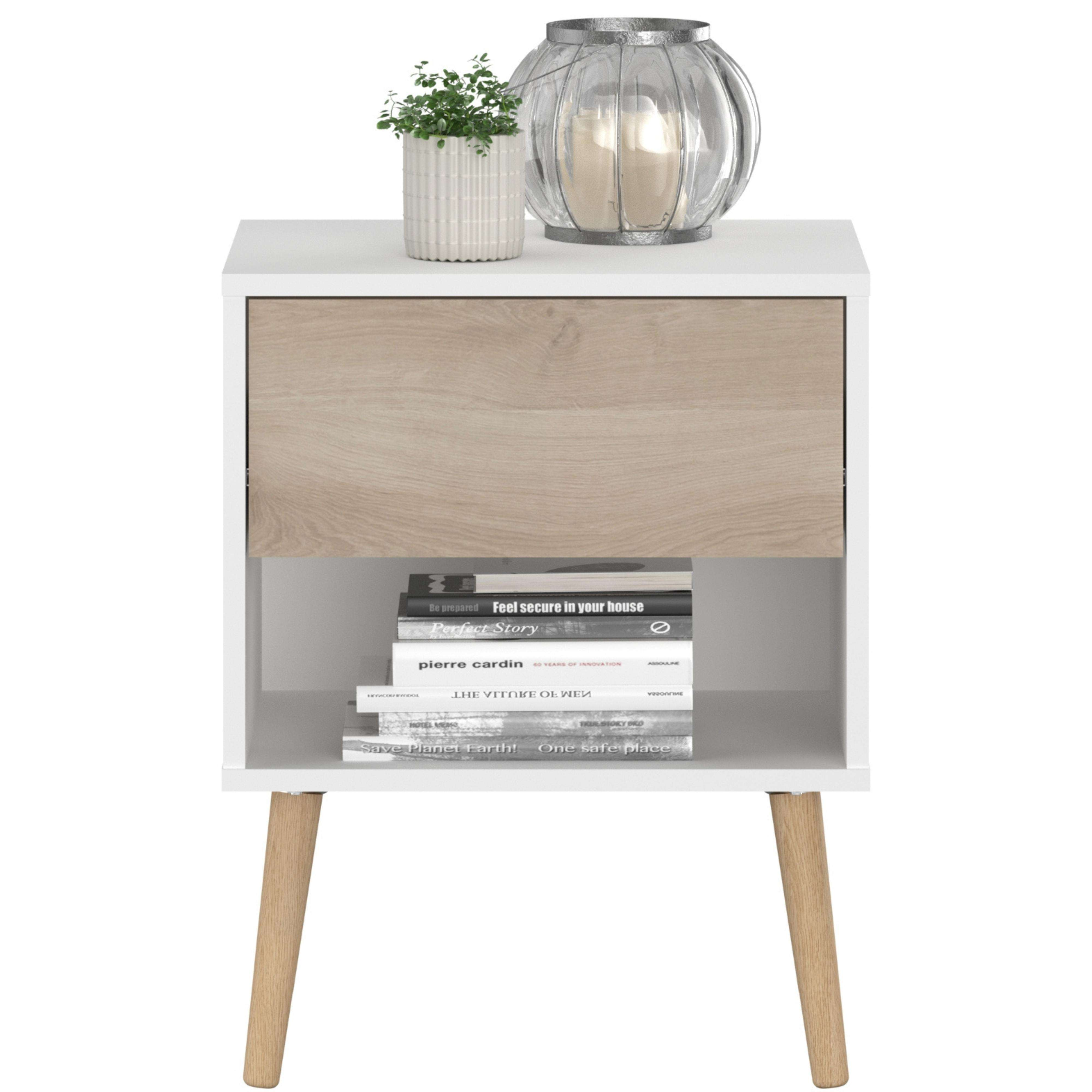 Una mesita de noche con cajón, libros y decoración.