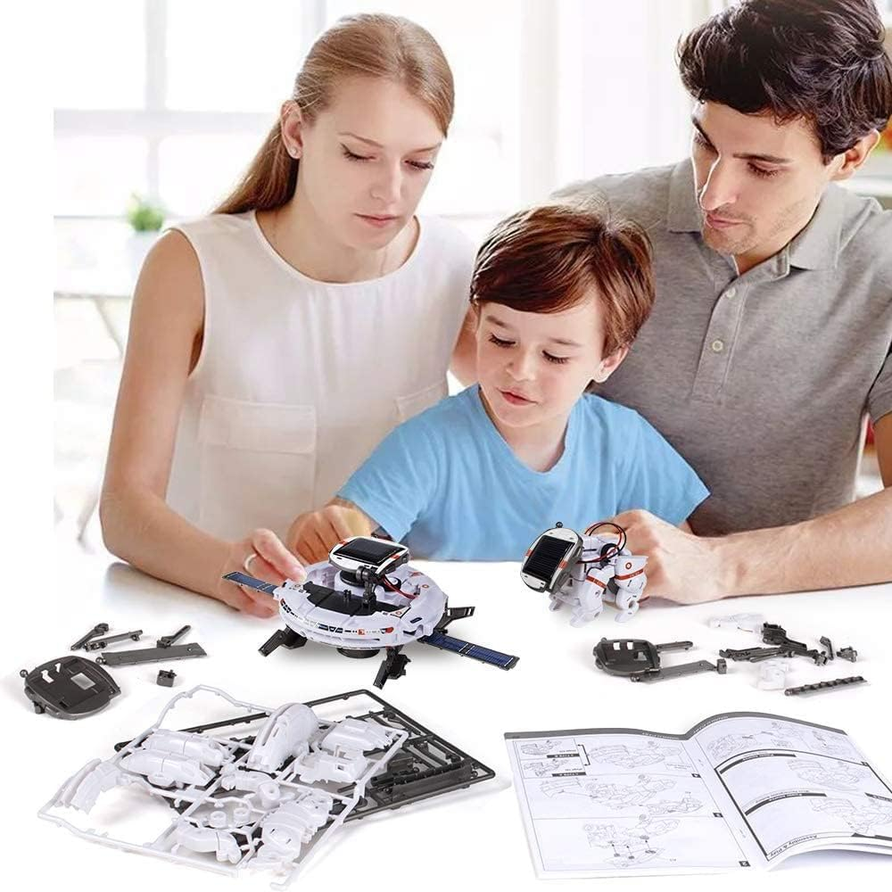 Familie baut Roboter mit Solarzellen, Teile und Anleitung auf dem Tisch.