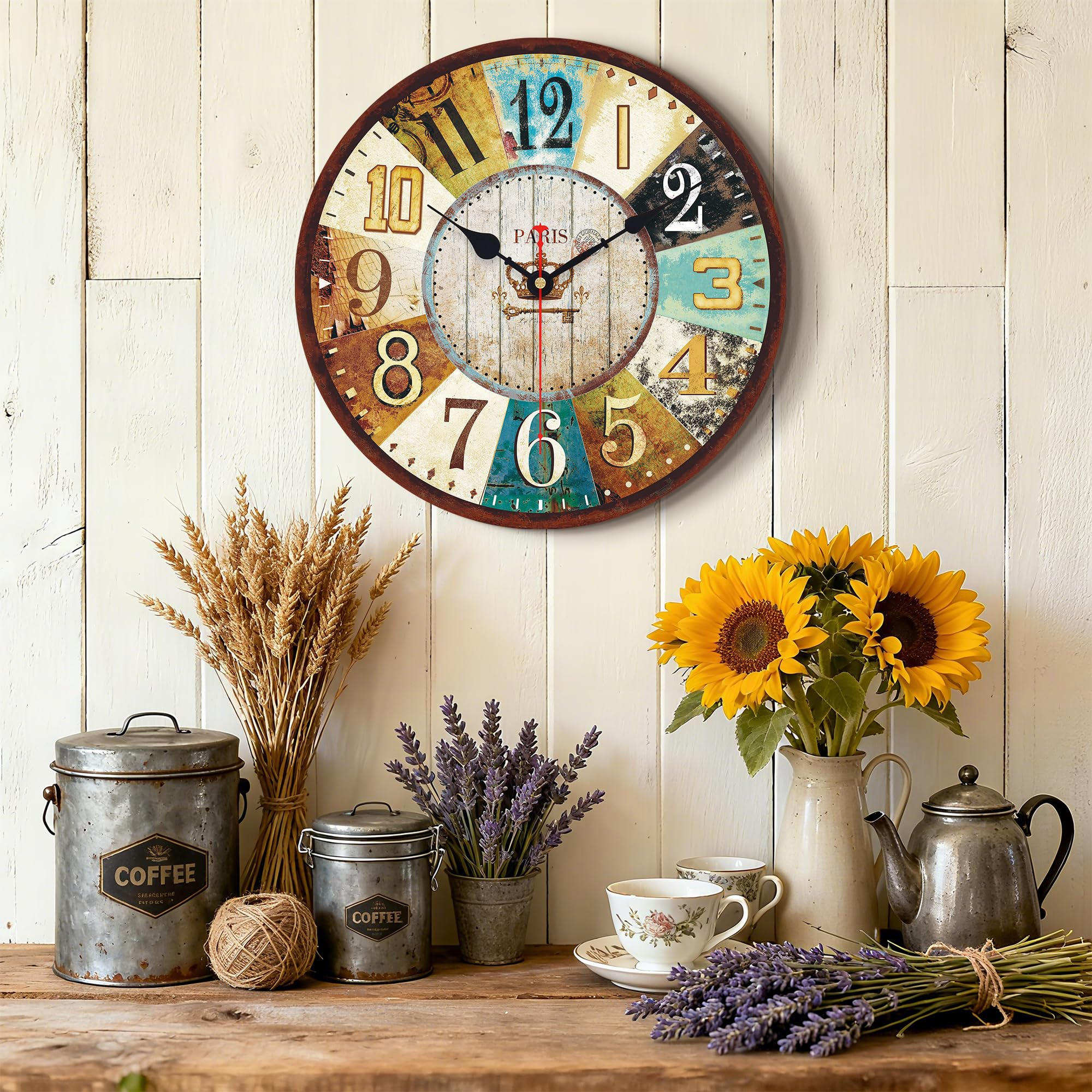 Eine Vintage-Uhr über einem Regal mit Kaffeetöpfen, Getreide, Lavendel und Sonnenblumen.