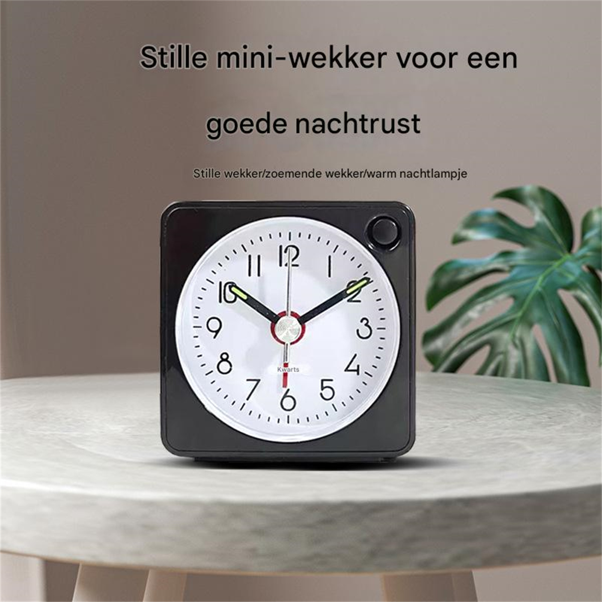 Ein schwarzer Wecker mit weißem Zifferblatt steht auf einem Tisch.