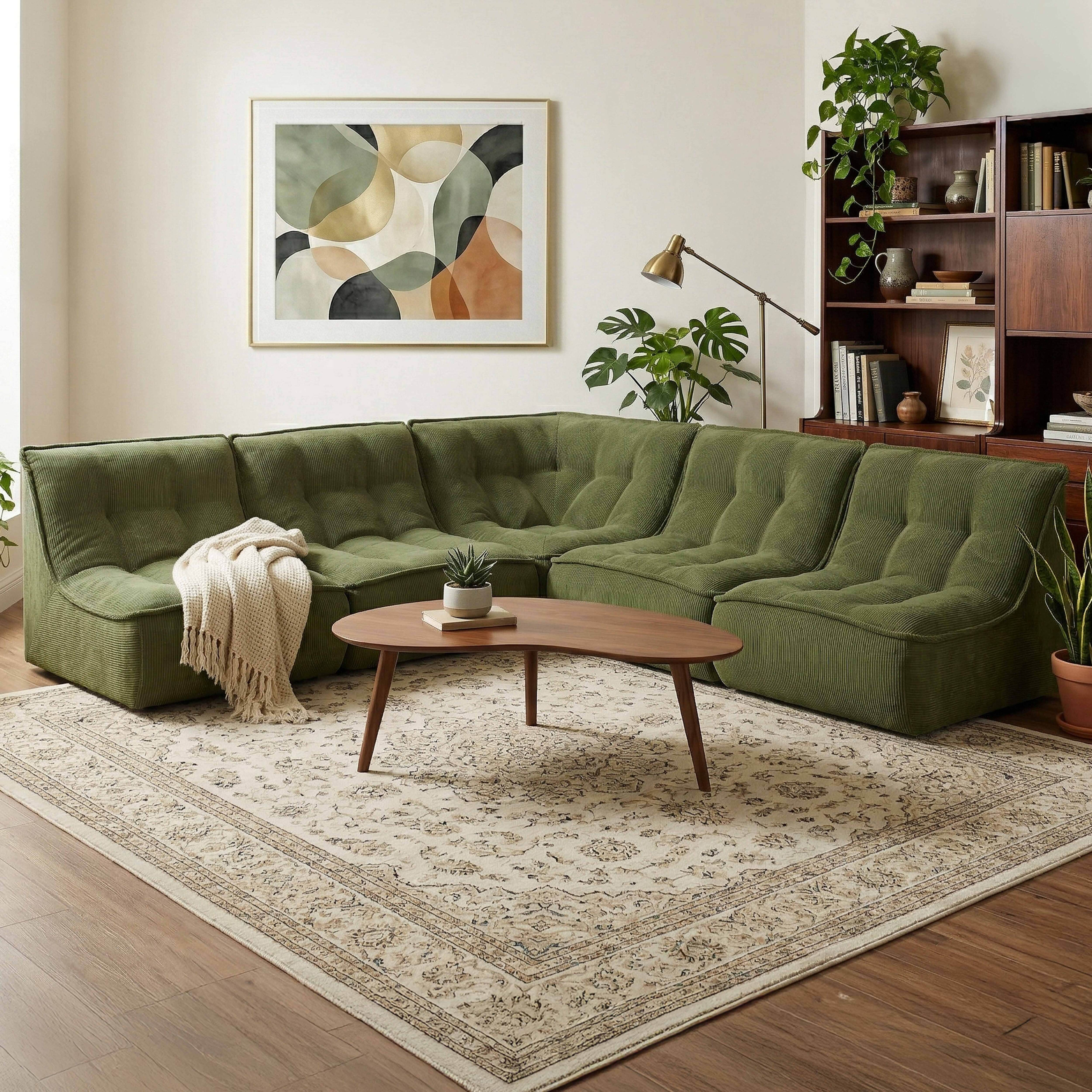 Grünes Cord-Sofa mit einem Holztisch und einer Decke.