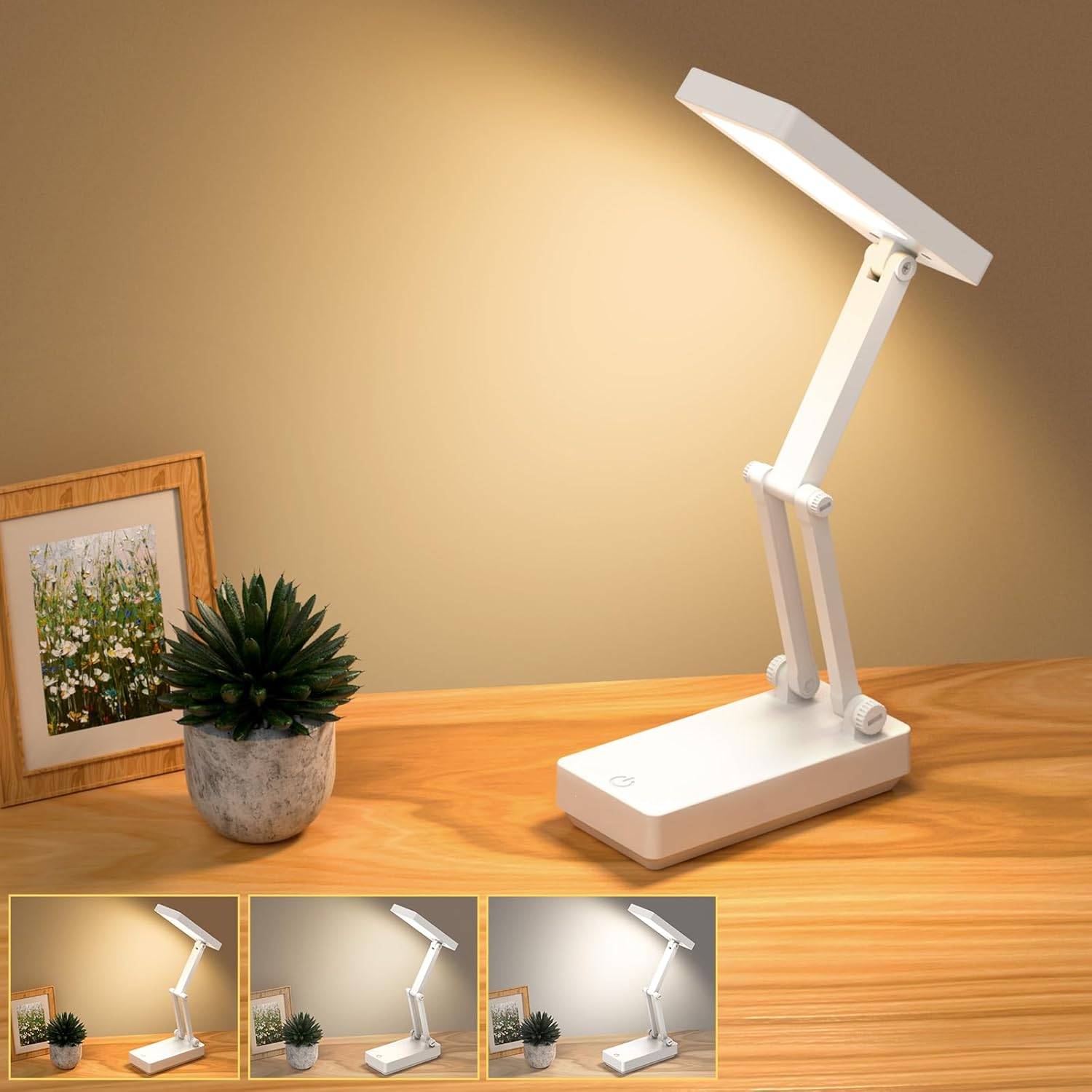 Weiße Faltlampe auf einem Holztisch mit Topfpflanze und Bild.