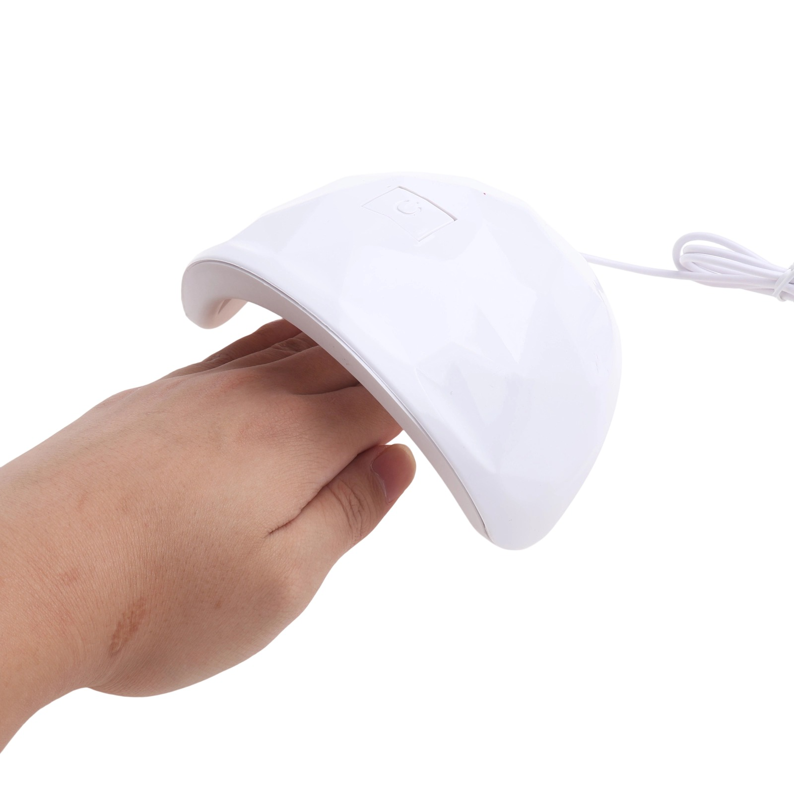 Eine weiße UV-Lampe für Nägel mit einer Hand darunter, auf weißem Hintergrund.