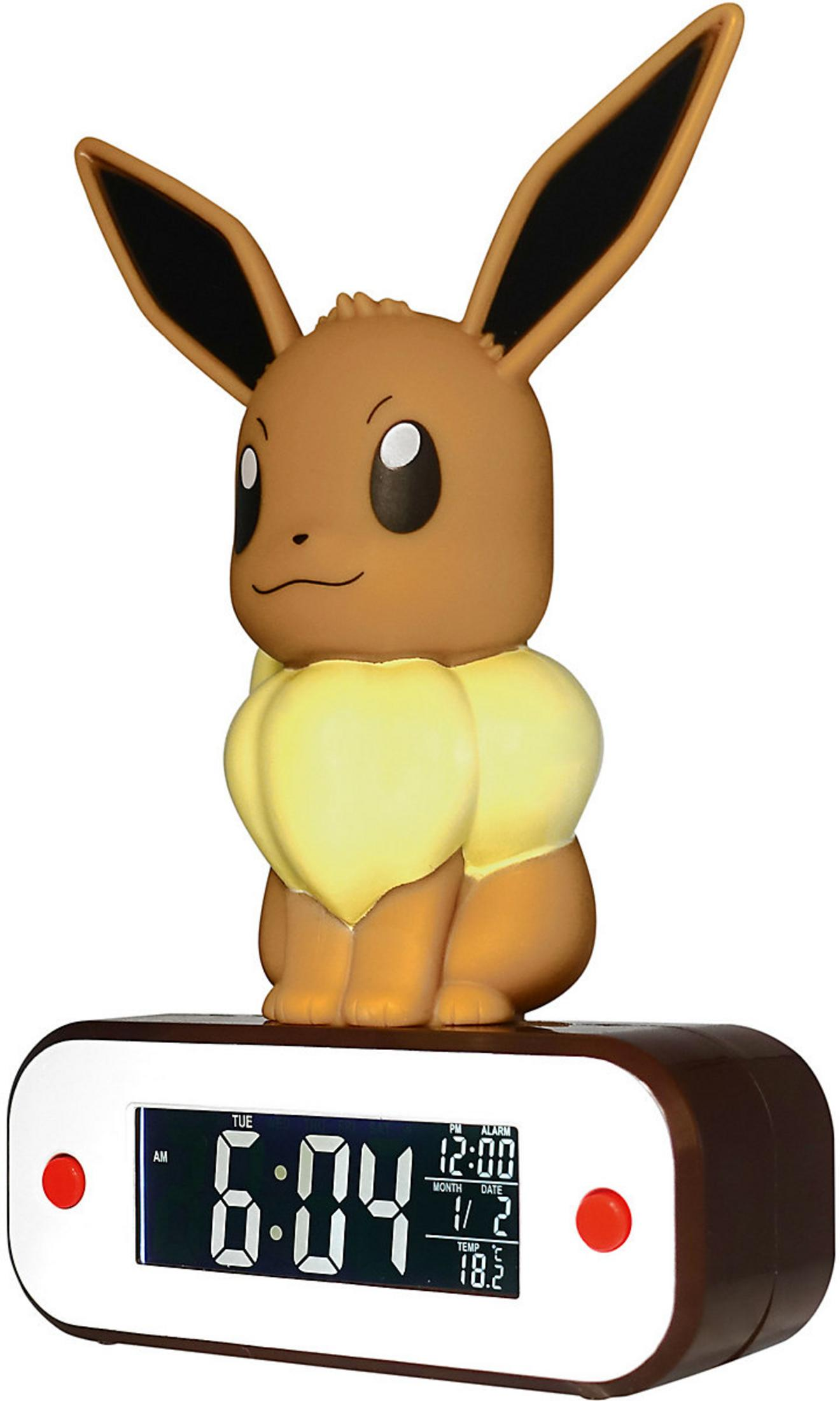 Brązowy budzik Eevee siedzi na brązowym cyfrowym budziku pokazującym 6:04.