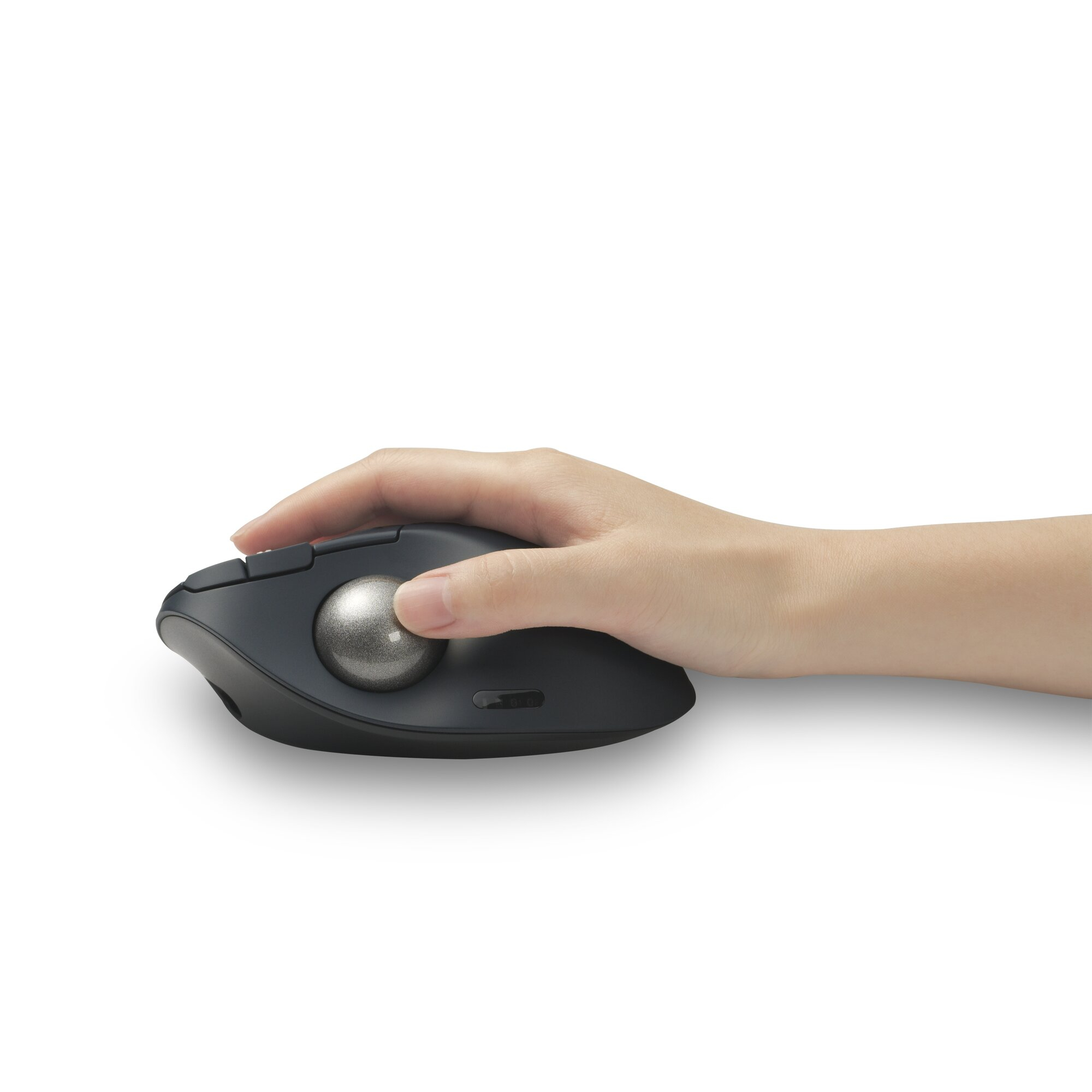 A hand on a dark trackball mouse with a silver ball.