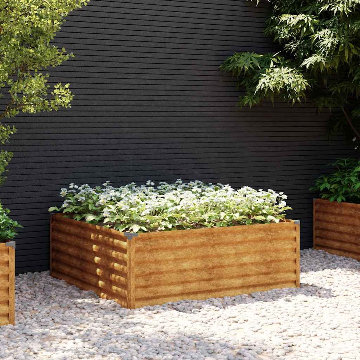 Ein hölzerner Hochbeet mit weißen Blumen vor einer dunklen Holzwand.