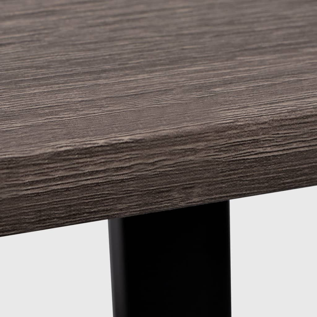 Nahaufnahme einer dunkelbraunen Holzmaserung auf einer Tischplatte mit einem schwarzen Bein.