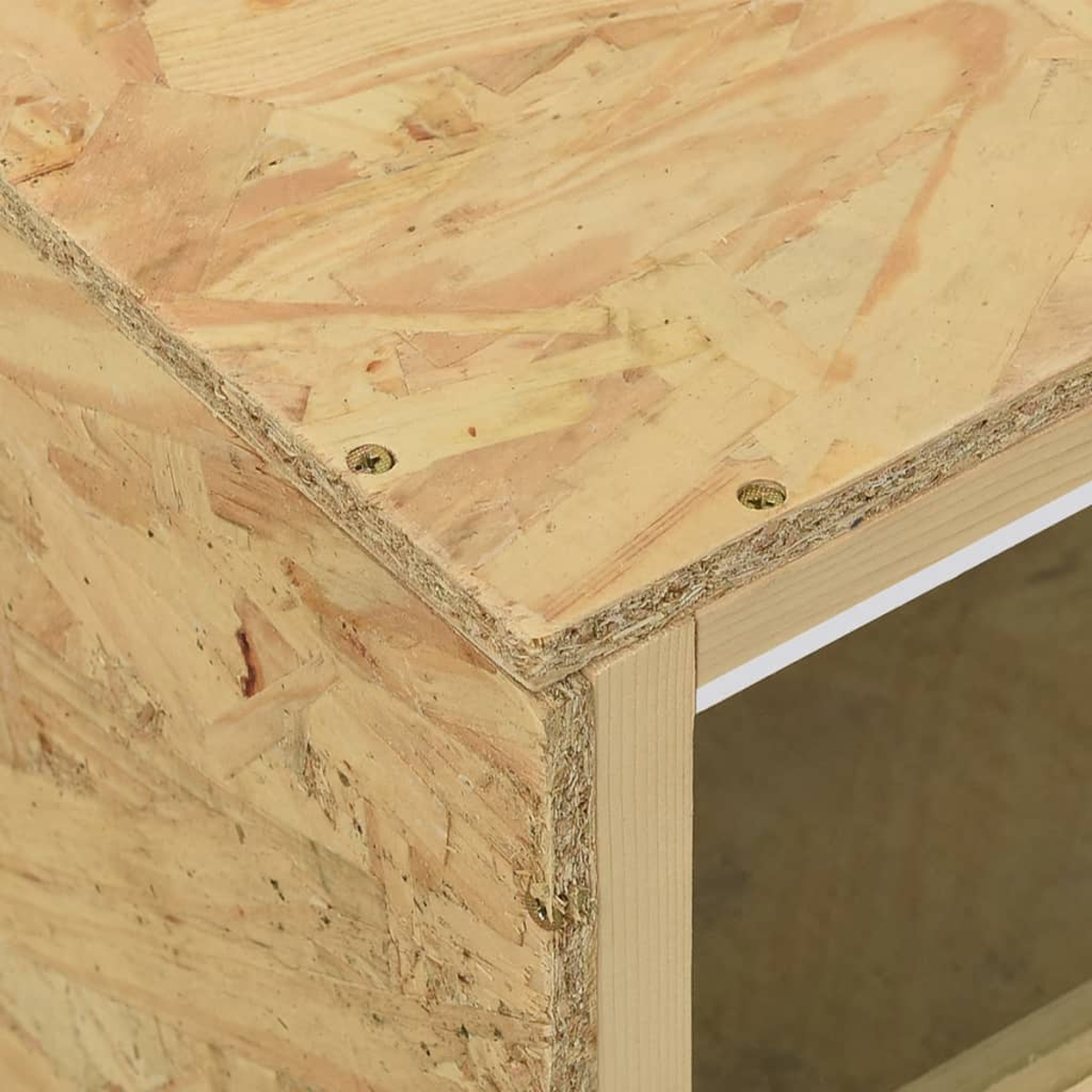 Nahaufnahme der Ecke eines OSB-Schrankes mit sichtbaren Holzspänen und Schrauben.
