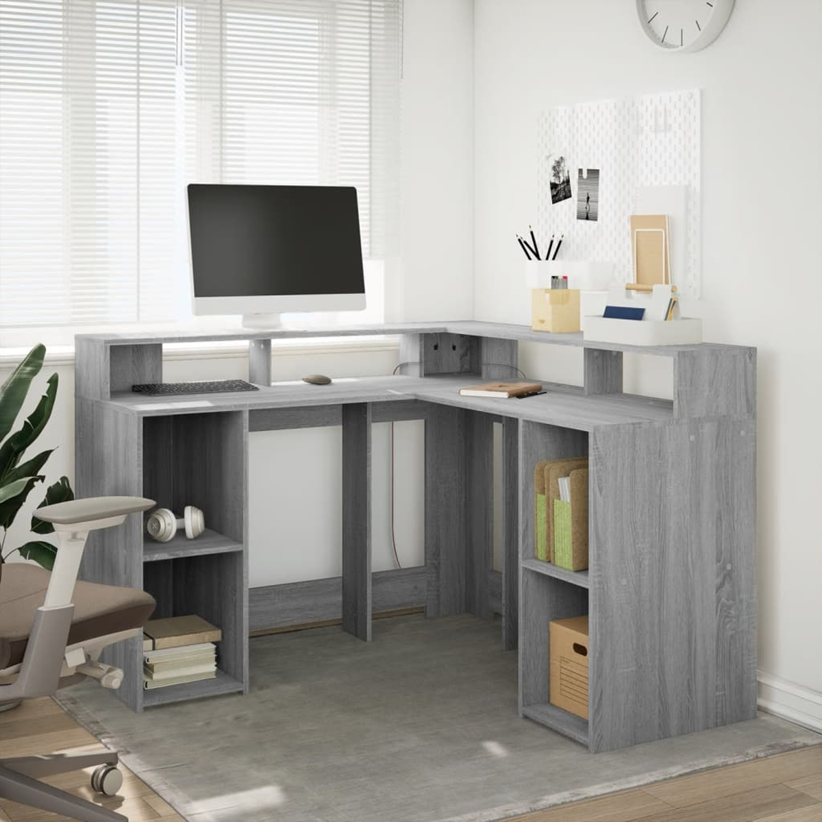 Ein Eckschreibtisch aus Holzimitat mit Monitor, Tastatur und Bürostuhl.