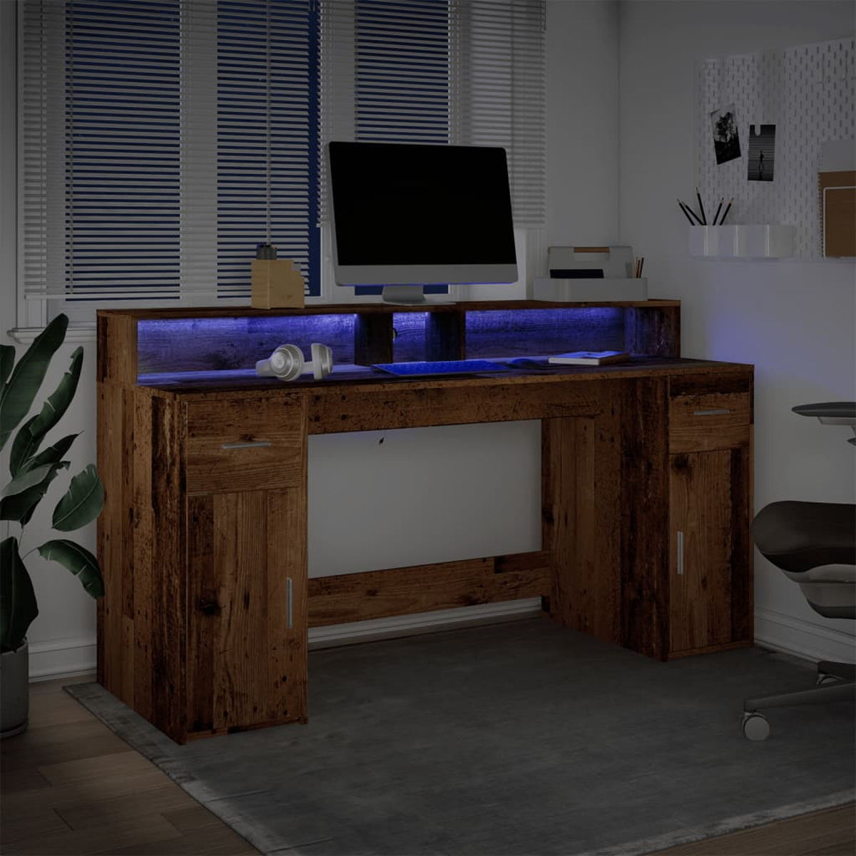 Ein hölzerner Schreibtisch mit blauem Licht, Monitor, Kopfhörern und Pflanzen.