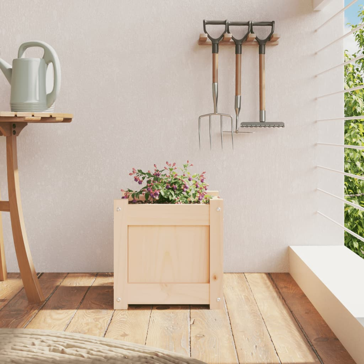 Eine Gießkanne steht auf einem Holztisch neben einem Blumenkasten mit lila Blumen. Gartengeräte hängen an der Wand.