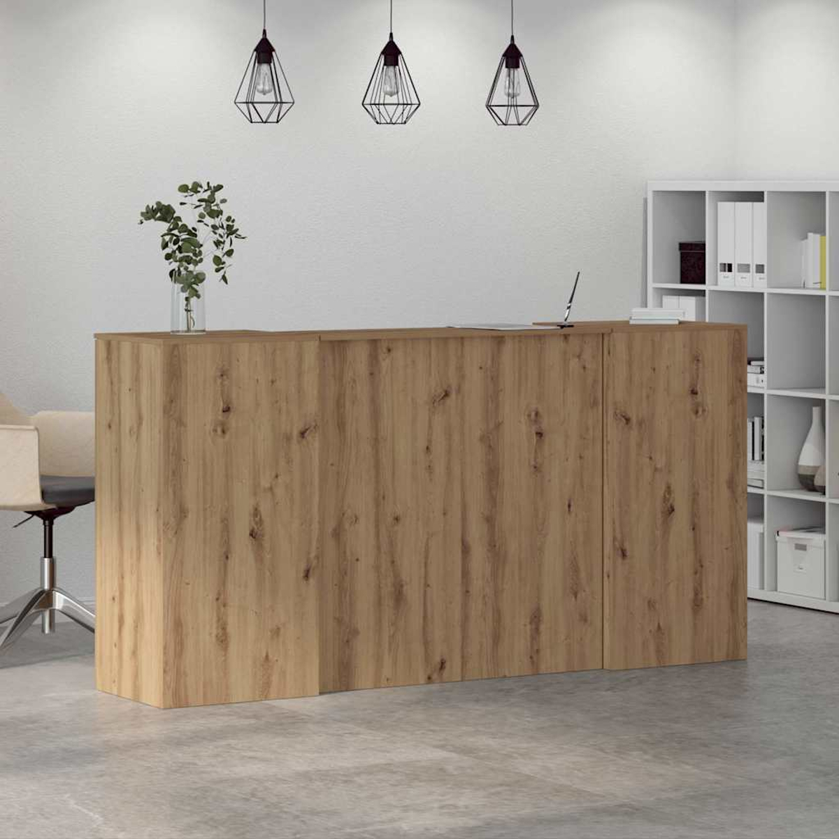 Ein hölzerner Empfangstresen mit Laptop und Pflanze. Ein Bürostuhl und ein Regal sind im Hintergrund.