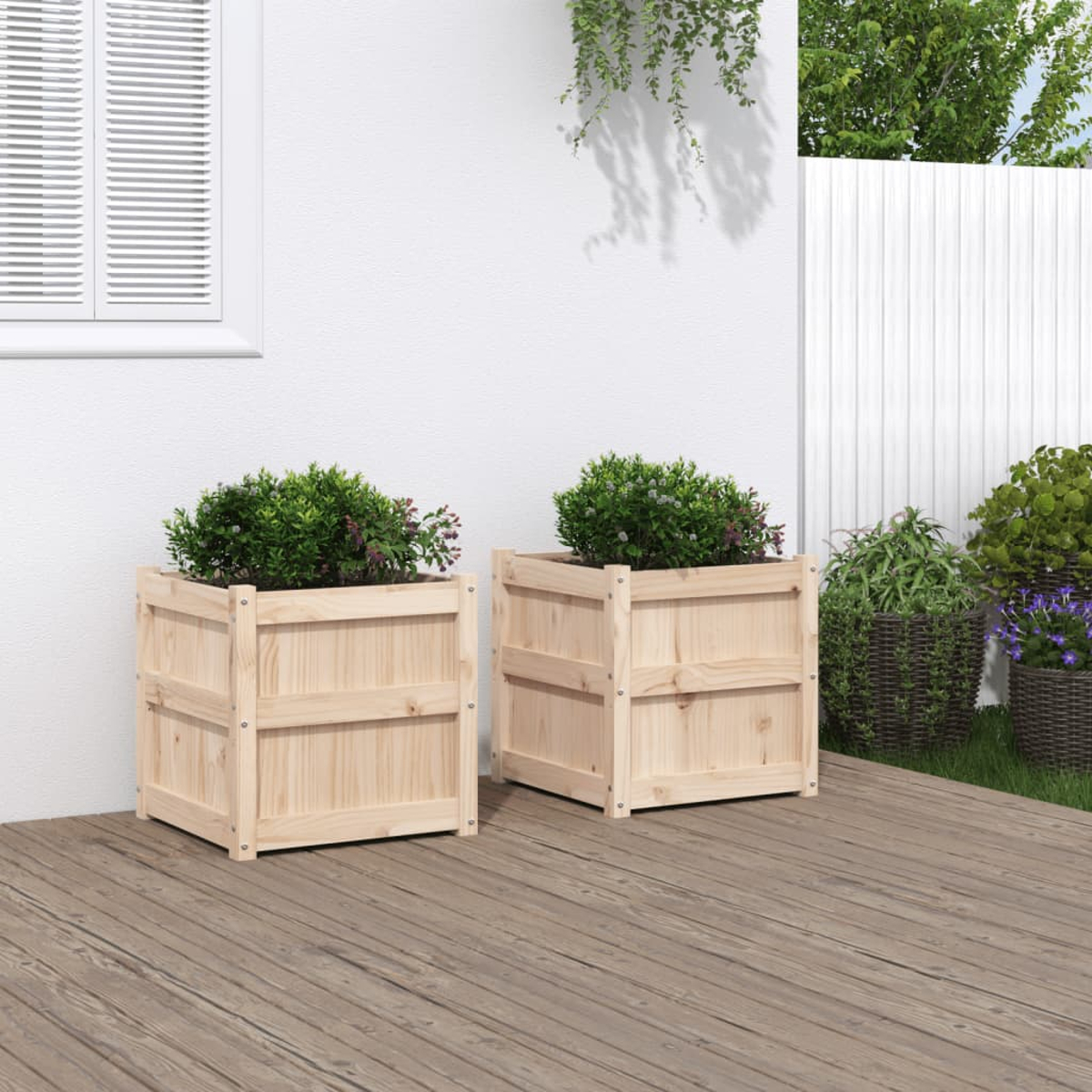 Zwei hölzerne Pflanzkästen mit grünen Büschen auf einer Holzterrasse.
