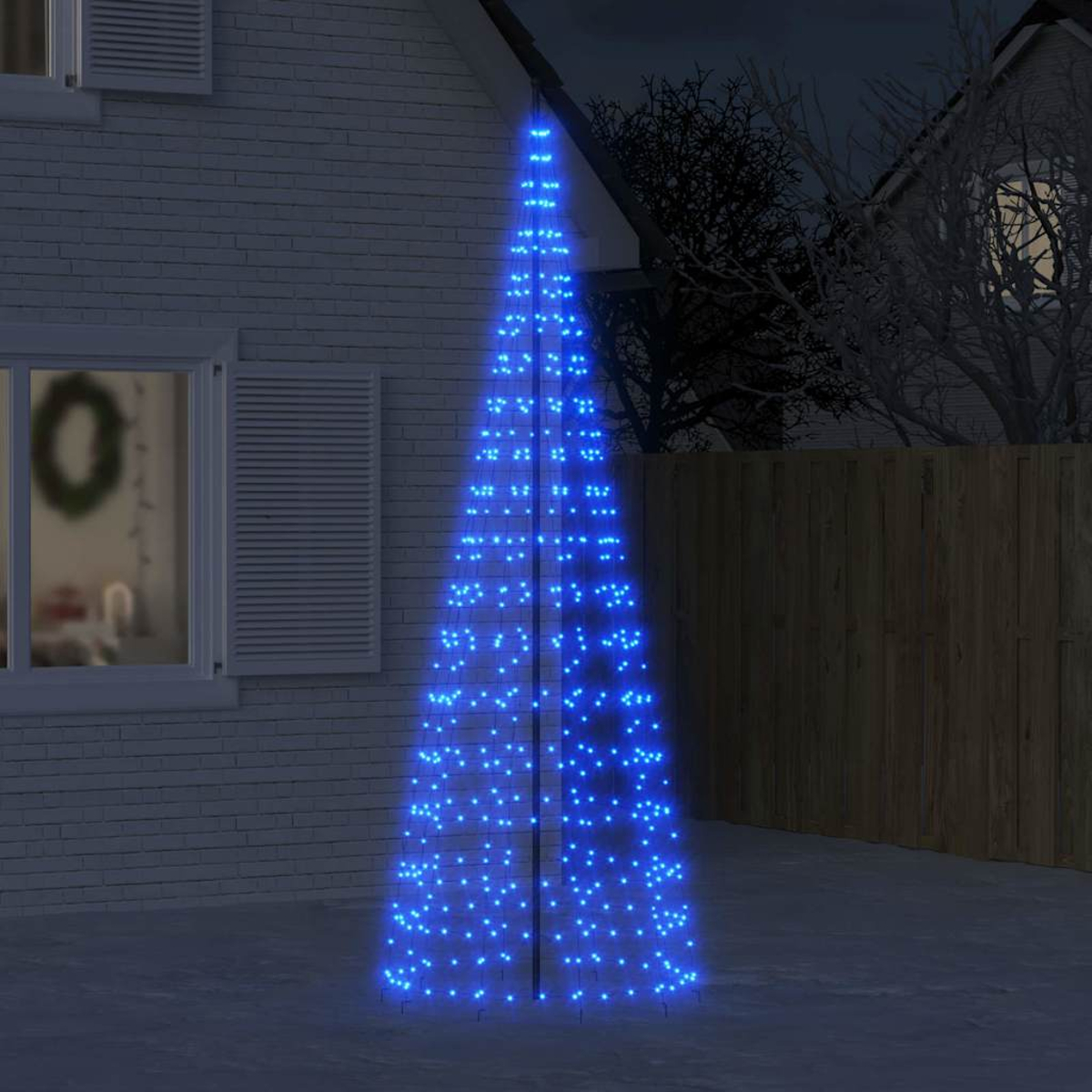 Ein konischer Weihnachtsbaum mit blauen Lichtern im Freien vor einem Haus.