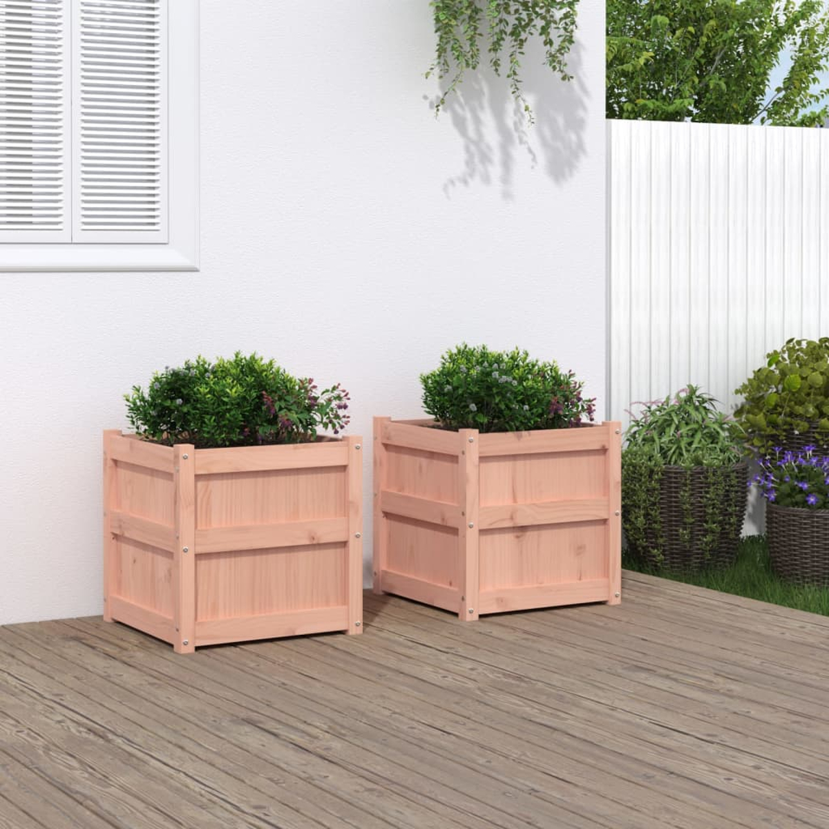 Zwei hölzerne Pflanzkübel mit grünen Pflanzen auf einer Holzterrasse vor einer weißen Wand.