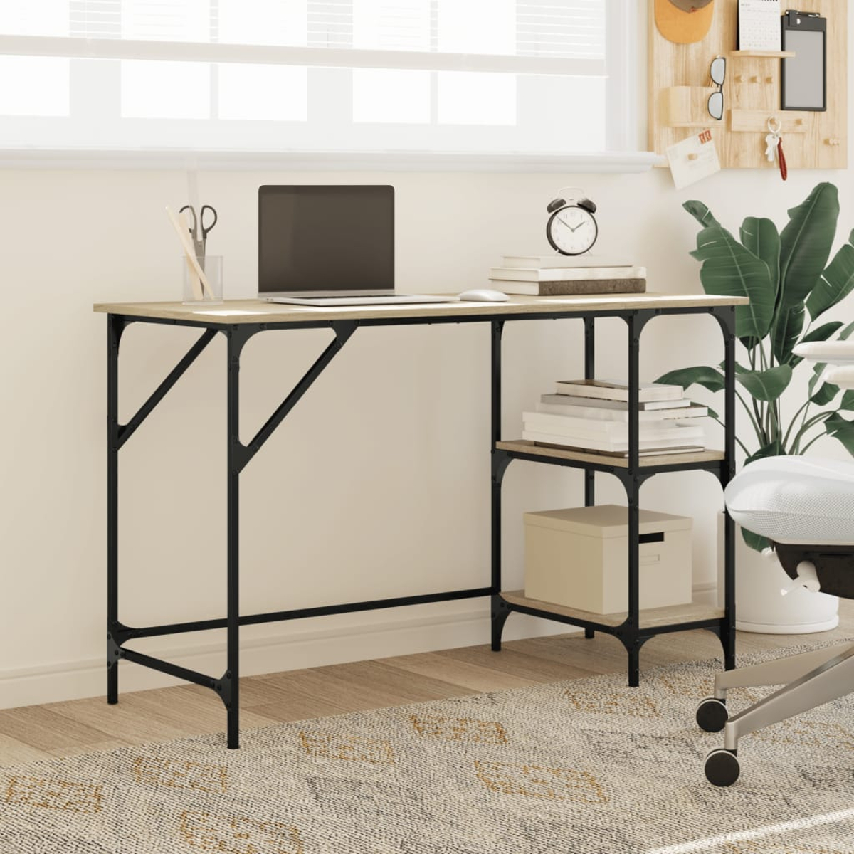 Ein minimalistischer Schreibtisch mit Laptop, Wecker und Büchern. Regale halten weitere Bücher und eine Kiste. Eine Pflanze ist in der Nähe.