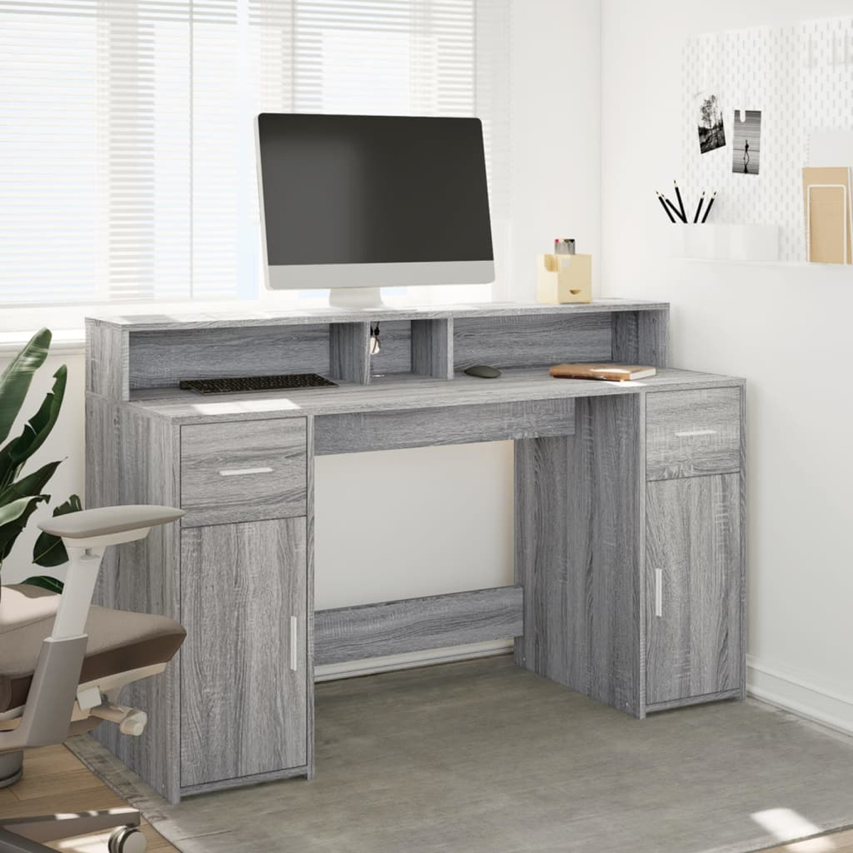Grauer Schreibtisch mit Computer, Tastatur, Maus und Pflanzen.