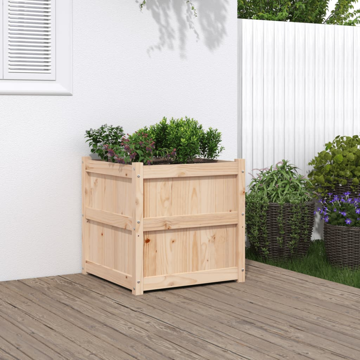 Holz-Blumenkasten mit Pflanzen auf einer Holzterrasse, weiße Wand im Hintergrund.