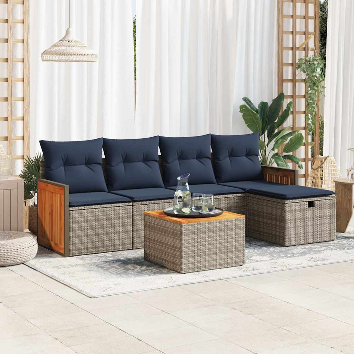 Graue Gartenlounge mit blauen Polstern, Holzakzenten und einem Couchtisch.
