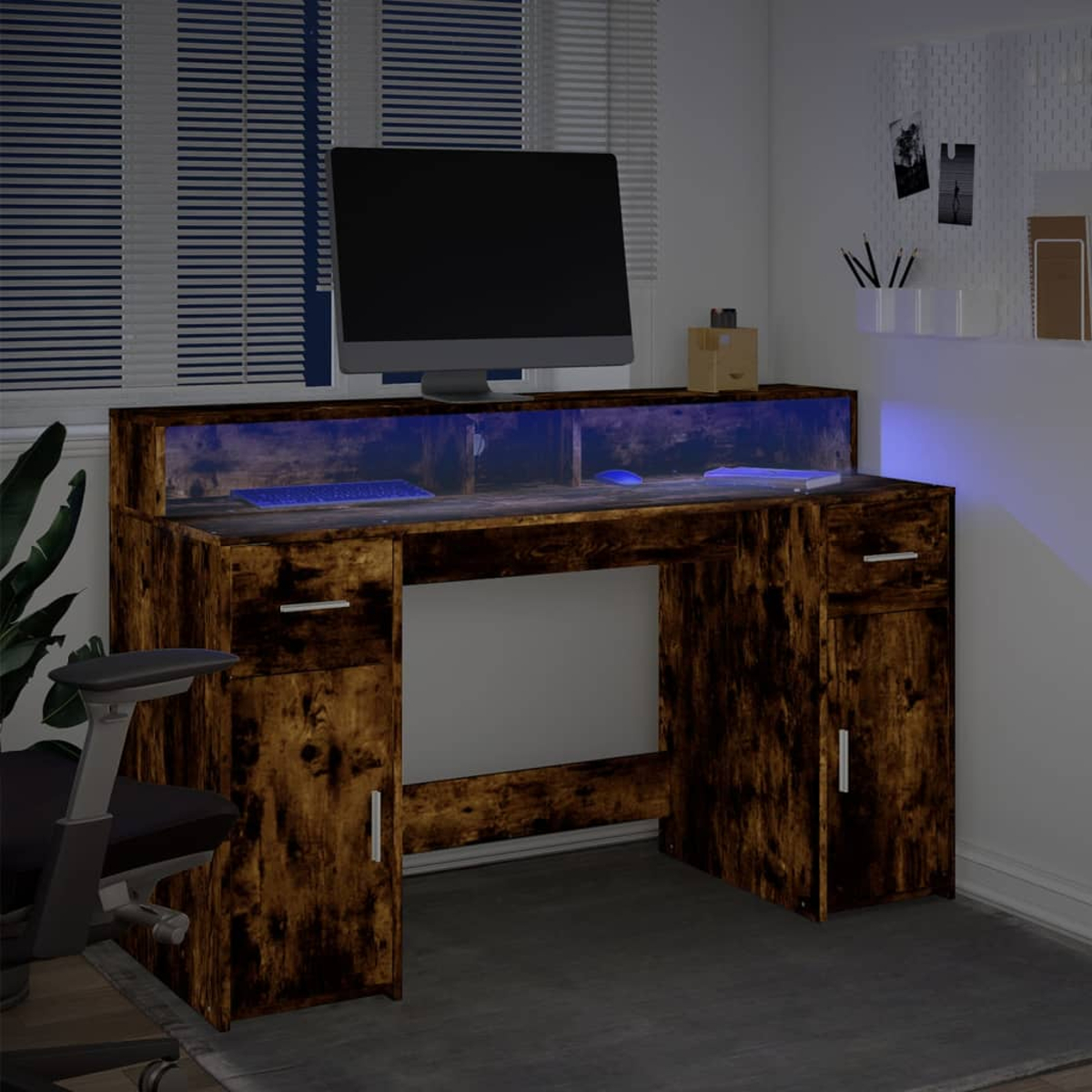 Ein Schreibtisch mit Monitor, Tastatur und Maus, beleuchtet mit blauem Licht.