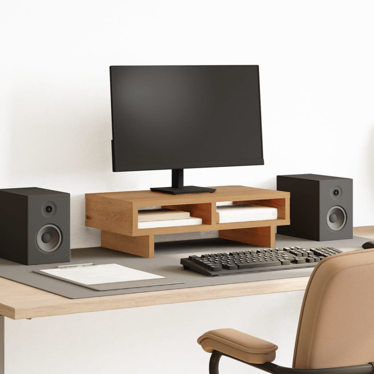 Ein Schreibtisch mit Monitor, Tastatur, Lautsprechern und Bürostuhl.