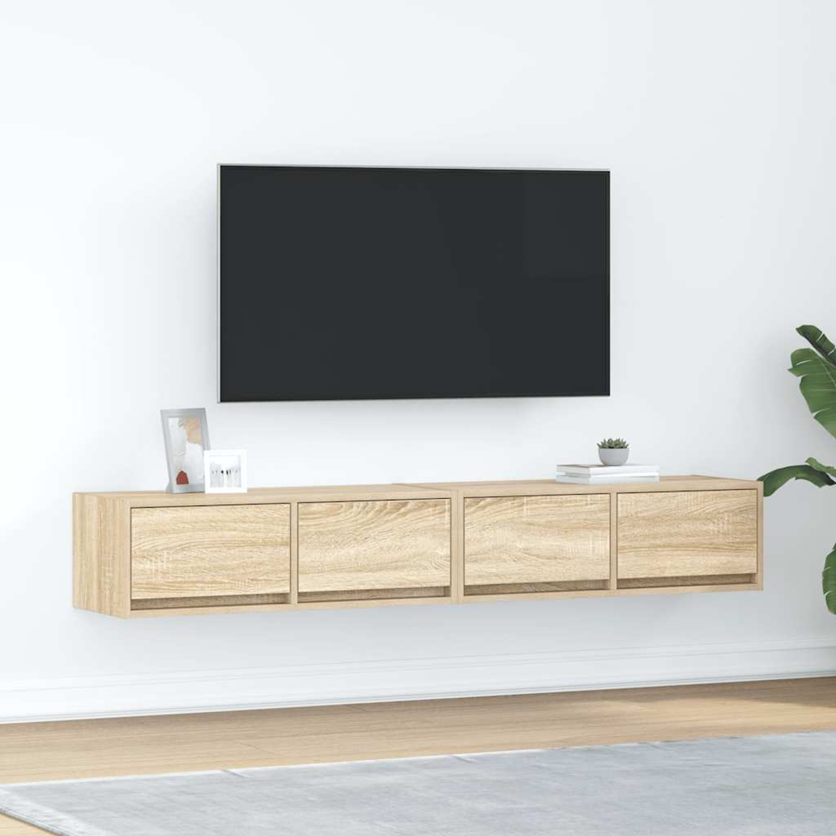 Ein schwebendes Holz-TV-Möbel mit vier Schubladen unter einem schwarzen Fernseher.