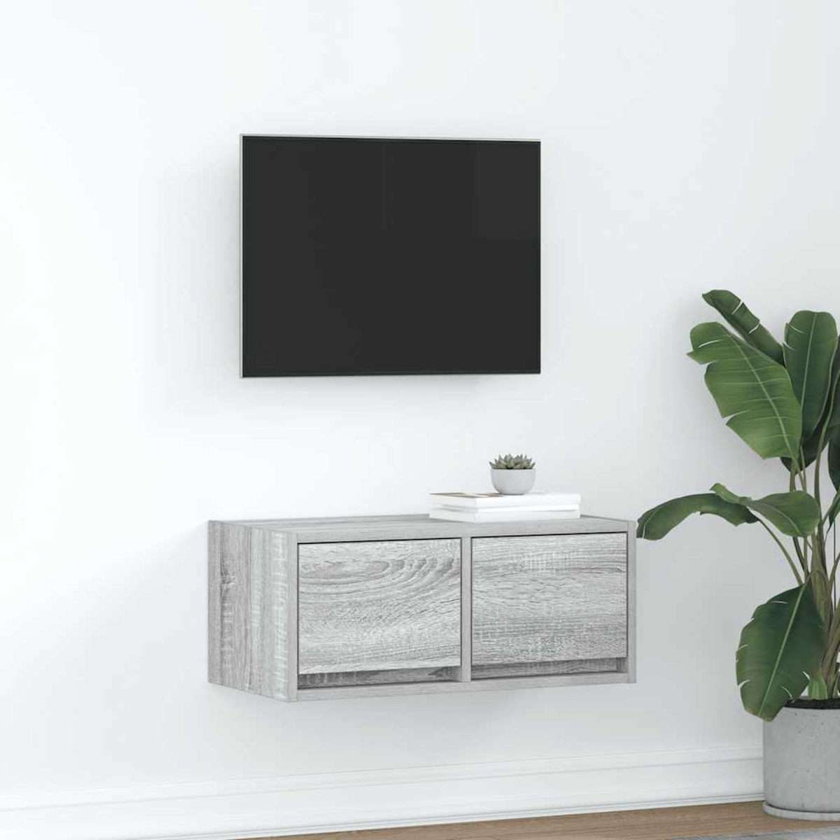 Ein graues Wandregal mit zwei Schubladen unter einem schwarzen Fernseher.