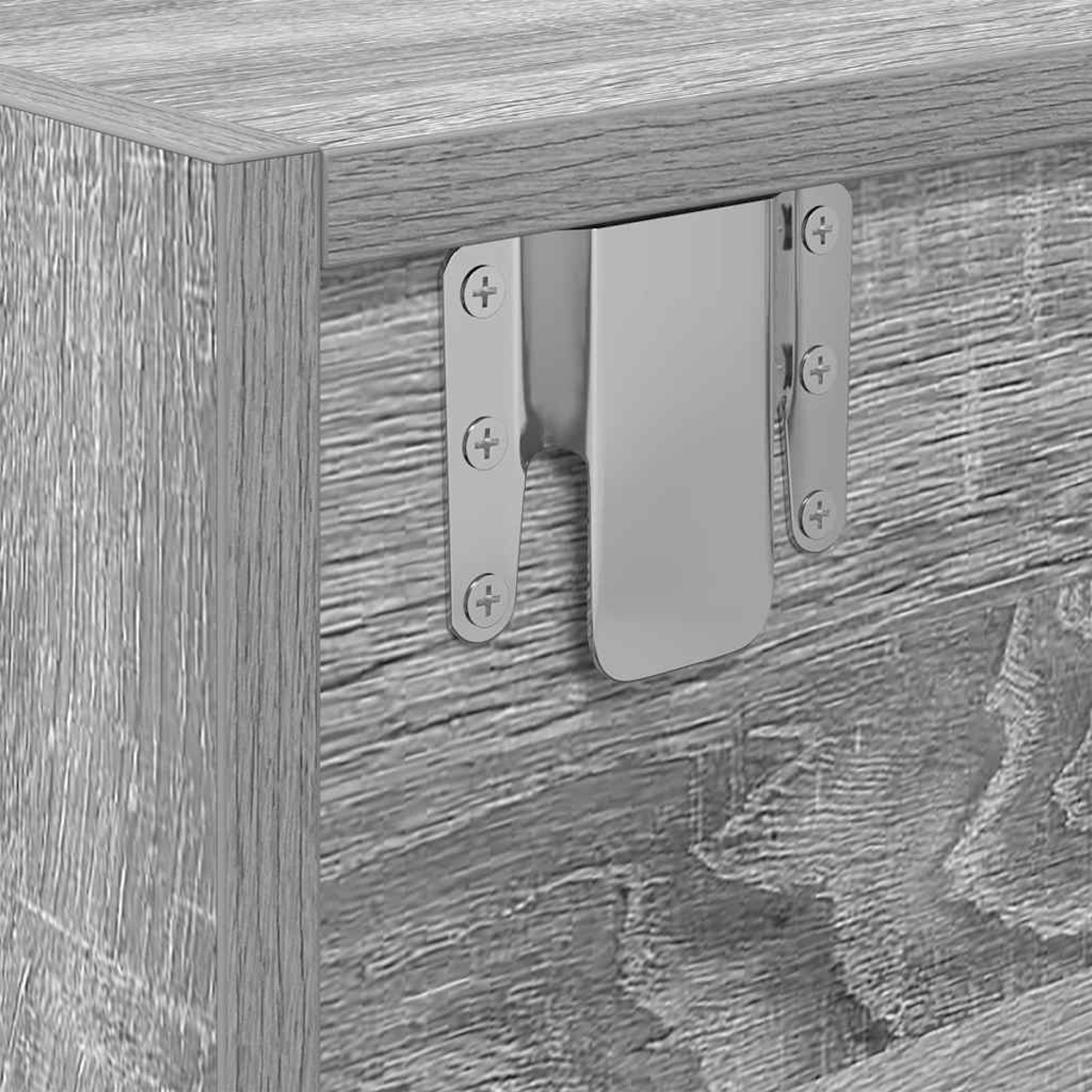 Ein Metallbeschlag ist an einer Holzmaserung befestigt.