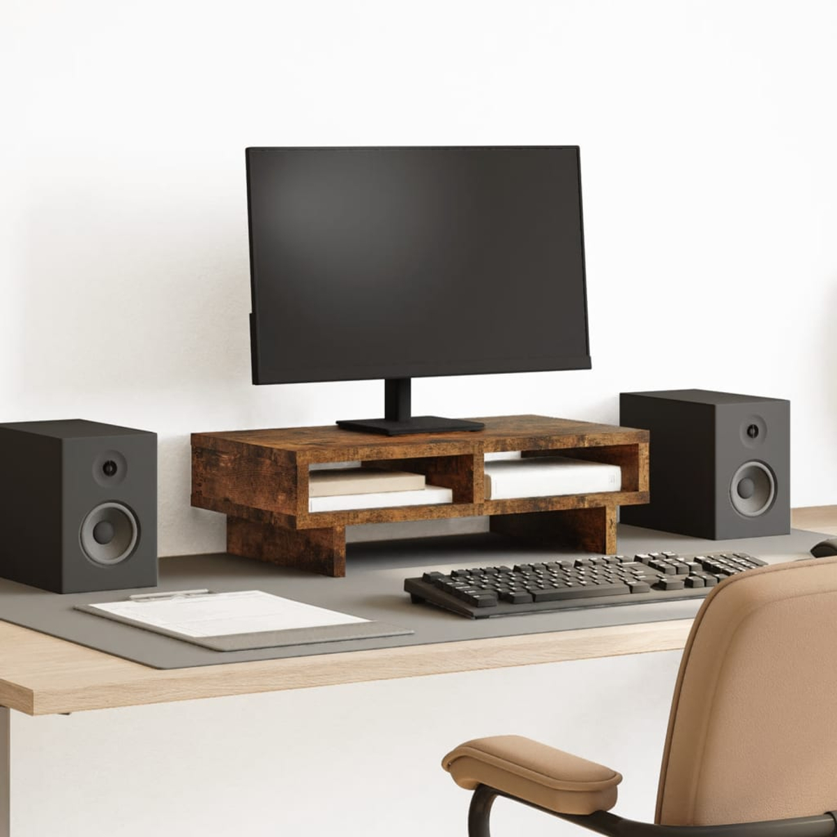 Ein Schreibtisch mit Monitor, Tastatur, zwei Lautsprechern und einem Holzständer.