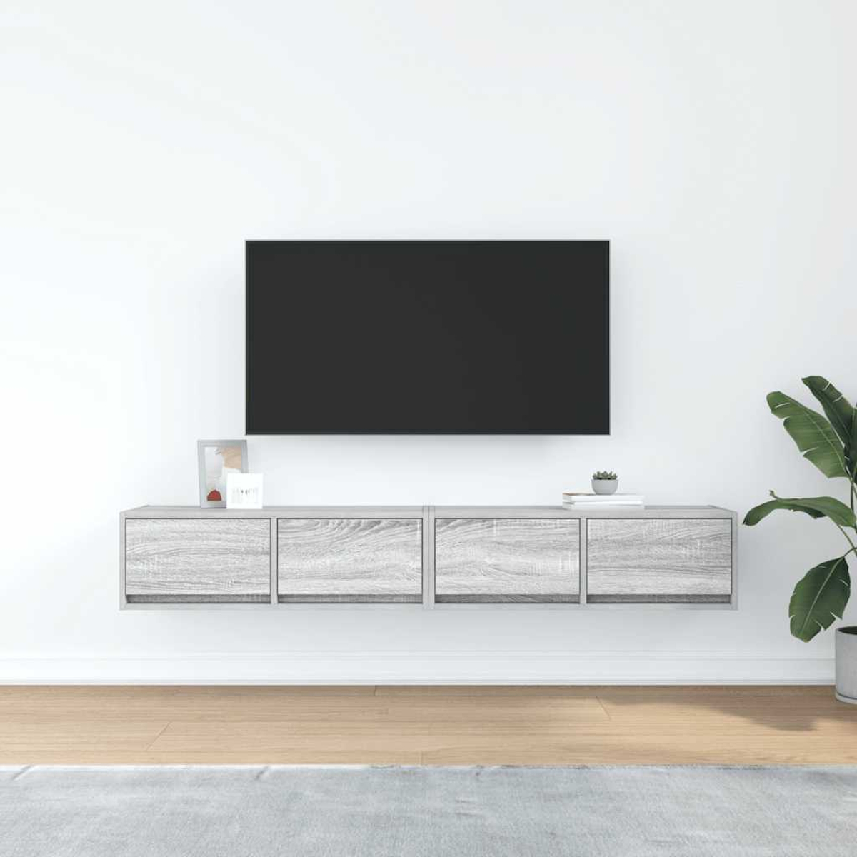 Ein moderner Wohnzimmeraufbau mit einem Fernseher, einem Wandregal und einer Pflanze.