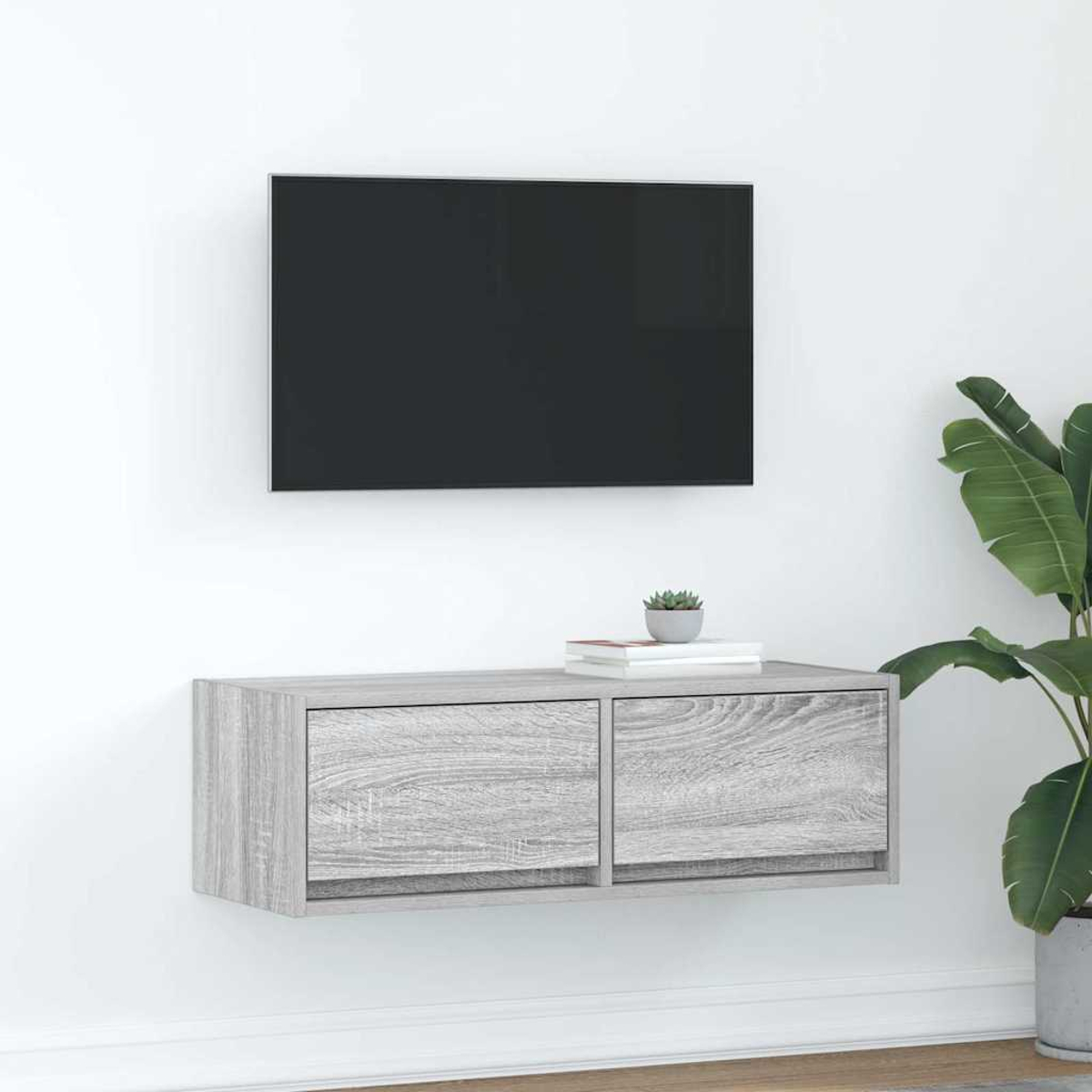 Ein schwebendes graues TV-Möbel mit zwei Schubladen unter einem schwarzen Fernseher.
