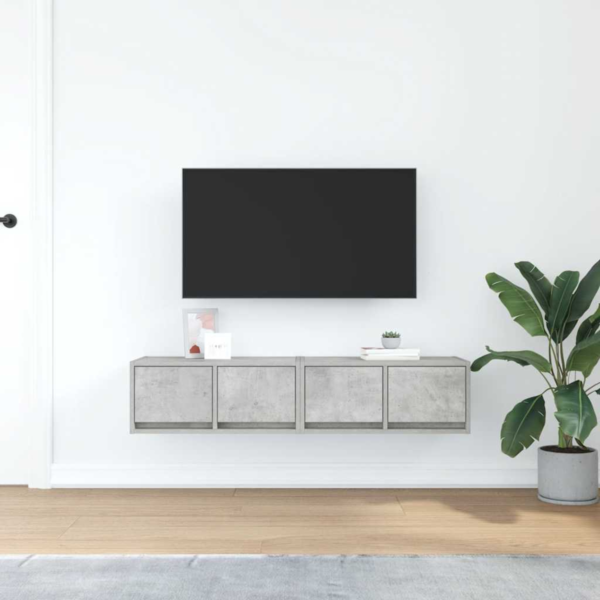 Ein moderner Wohnraum mit einem schwarzen Fernseher, der an einer weißen Wand hängt.