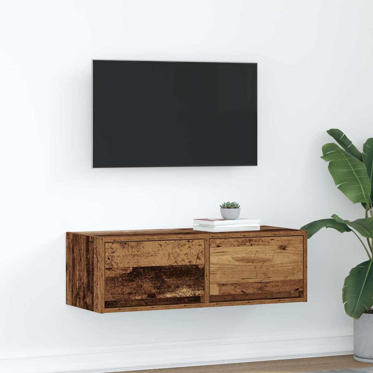 Ein schwebendes Holz-TV-Möbel unter einem schwarzen Fernseher an einer weißen Wand.