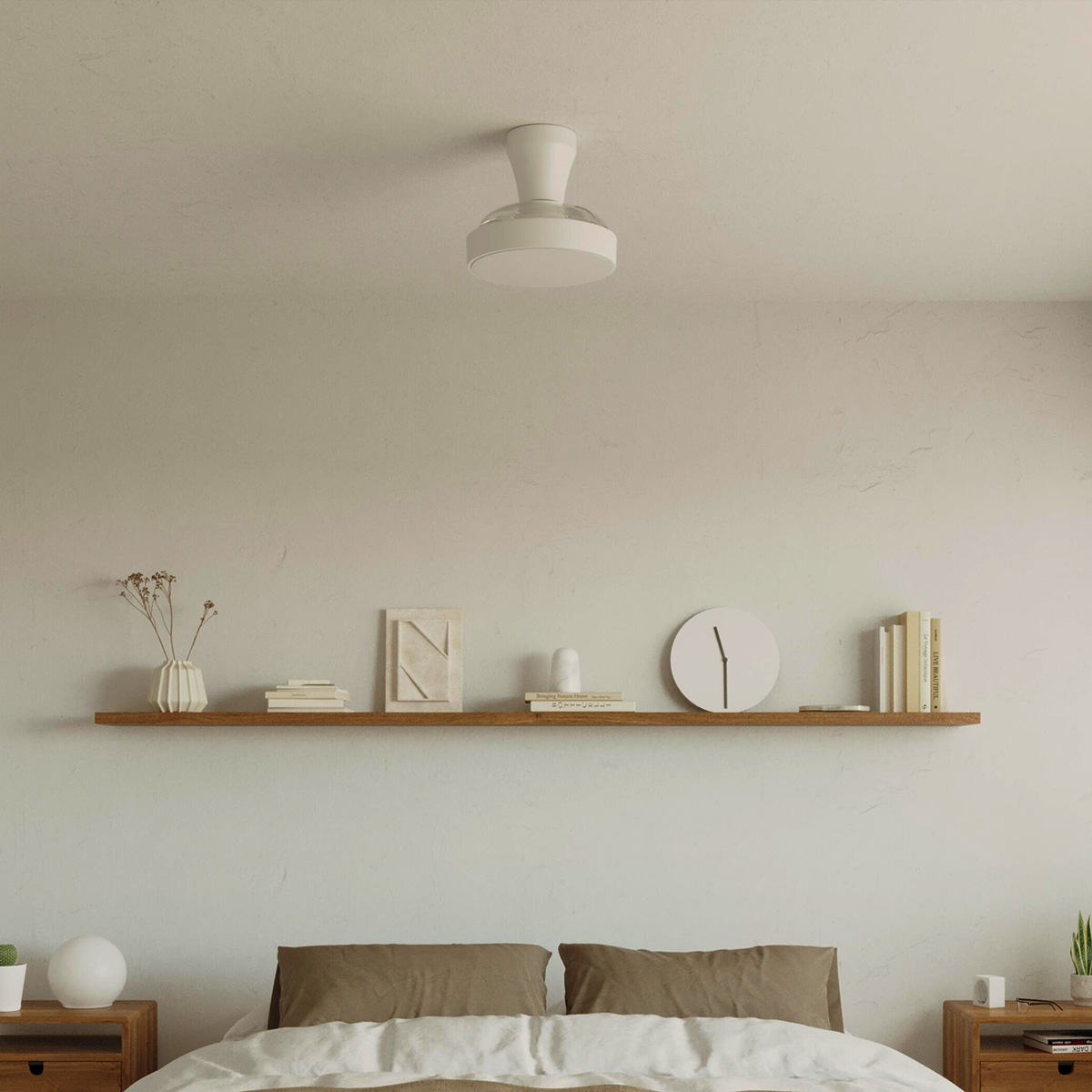 Un ventilador de techo blanco está montado sobre una estantería de madera con decoración. Debajo hay dos almohadas.