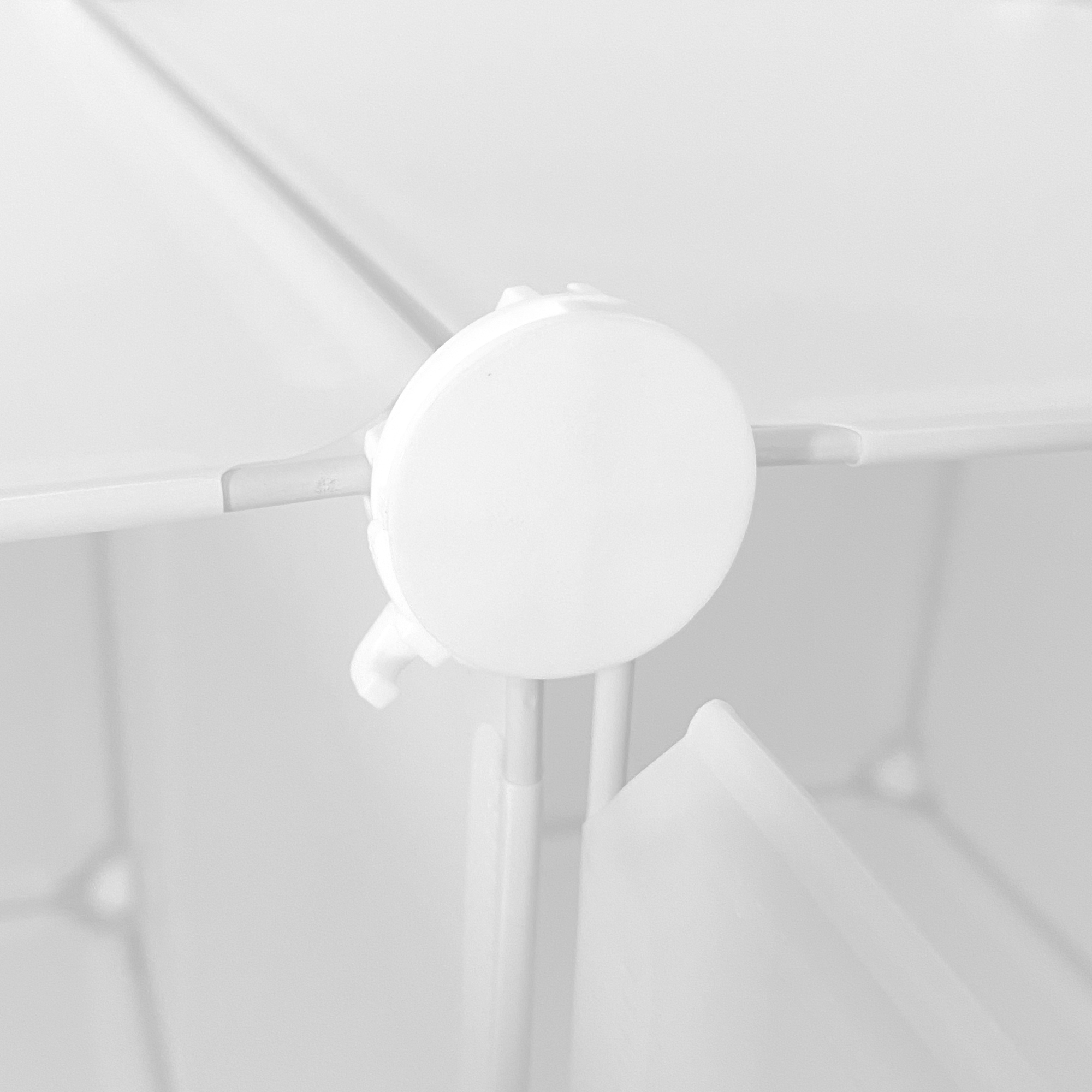 Un conector blanco de plástico une dos paneles blancos.