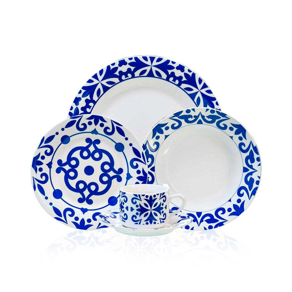 Un juego de vajilla blanco con motivos azules, incluyendo platos y una taza con platillo.