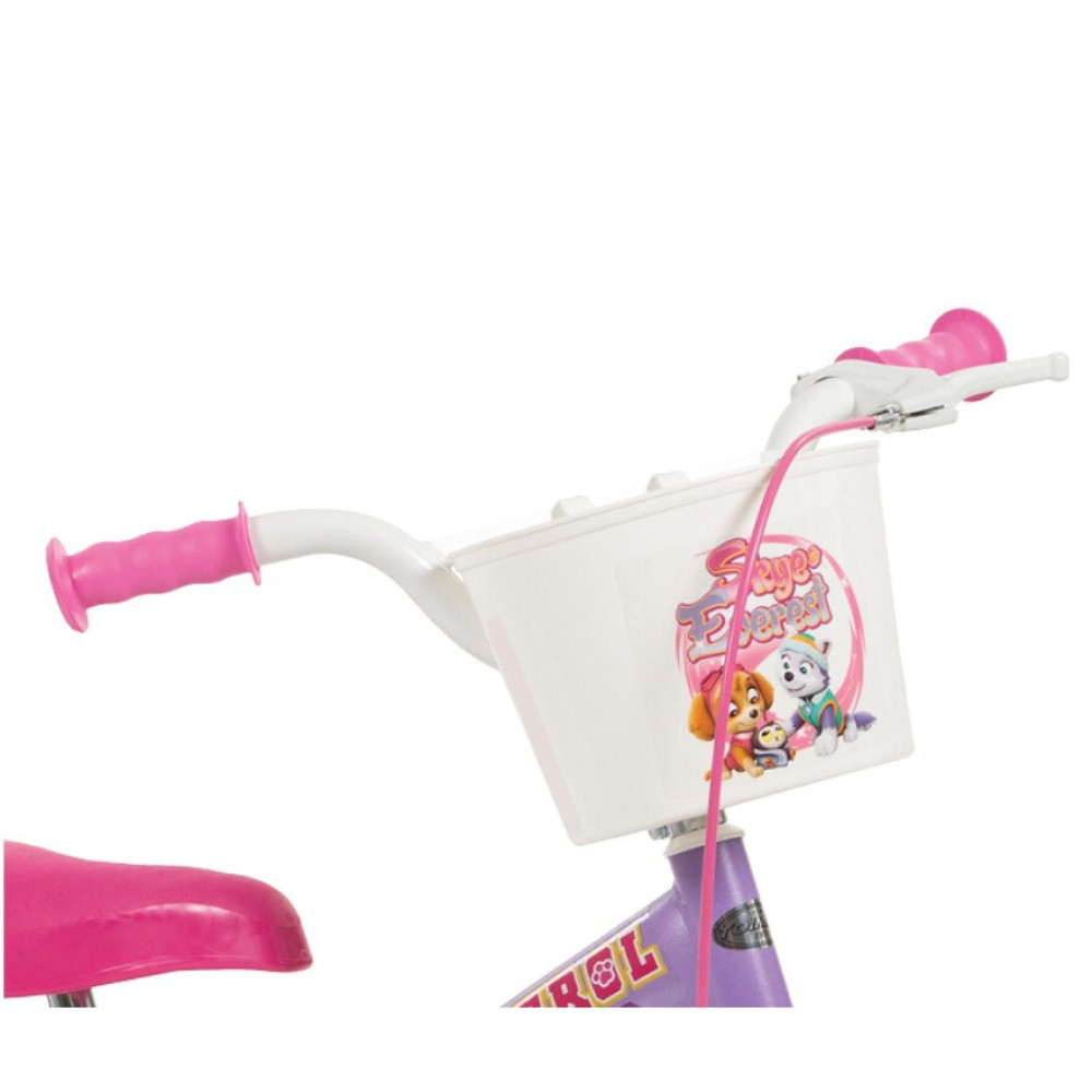 Zbliżenie na różową kierownicę roweru z białym koszykiem z postaciami Psiego Patrolu.