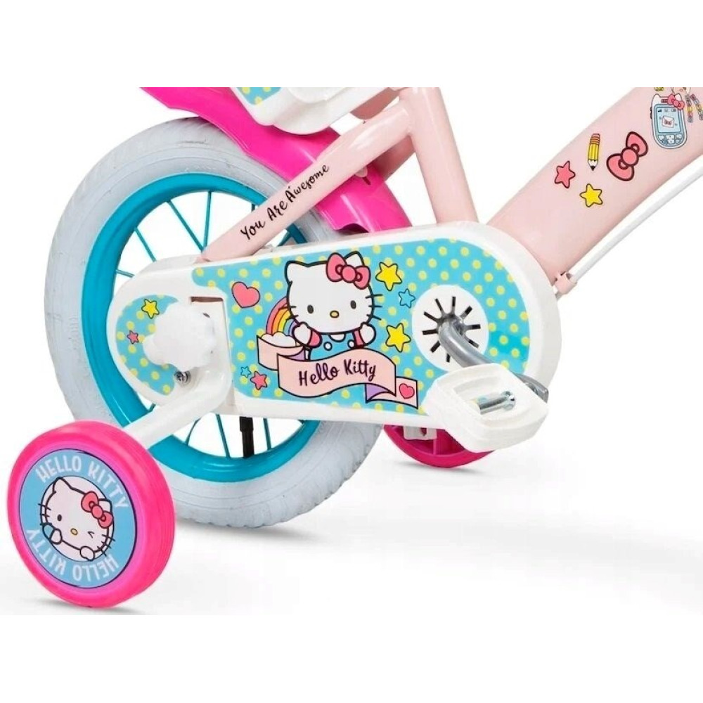 Różowy rower dziecięcy z naklejkami Hello Kitty, kółkami bocznymi i niebieskimi obręczami.