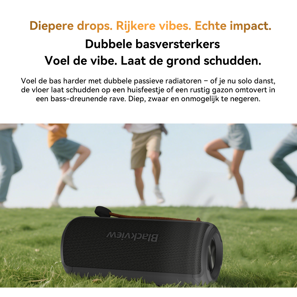 Black speaker on grass with people dancing in the background.