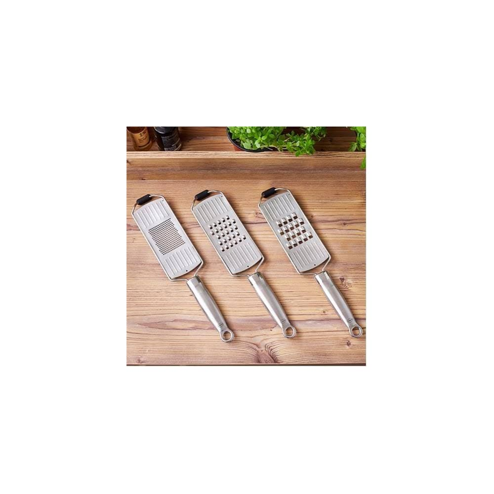 Tre grattugie da cucina in metallo con manici giacciono su un tavolo di legno.